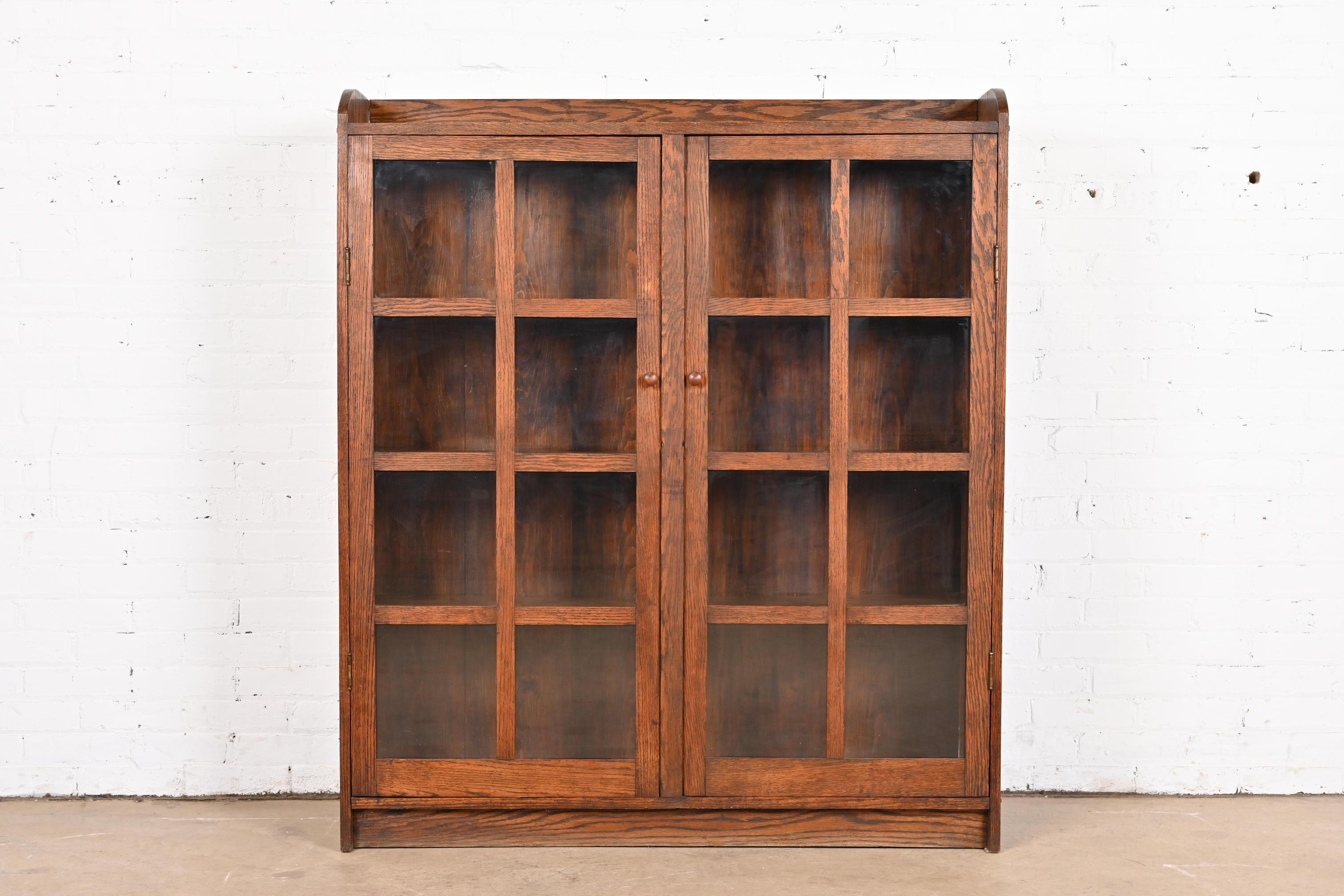 A gorgeous antique Mission or Arts & Crafts bookcase cabinet

In the manner of Stickley Brothers

USA, Circa 1900

Carved oak, with mullioned glass front doors.

Measures: 47.25