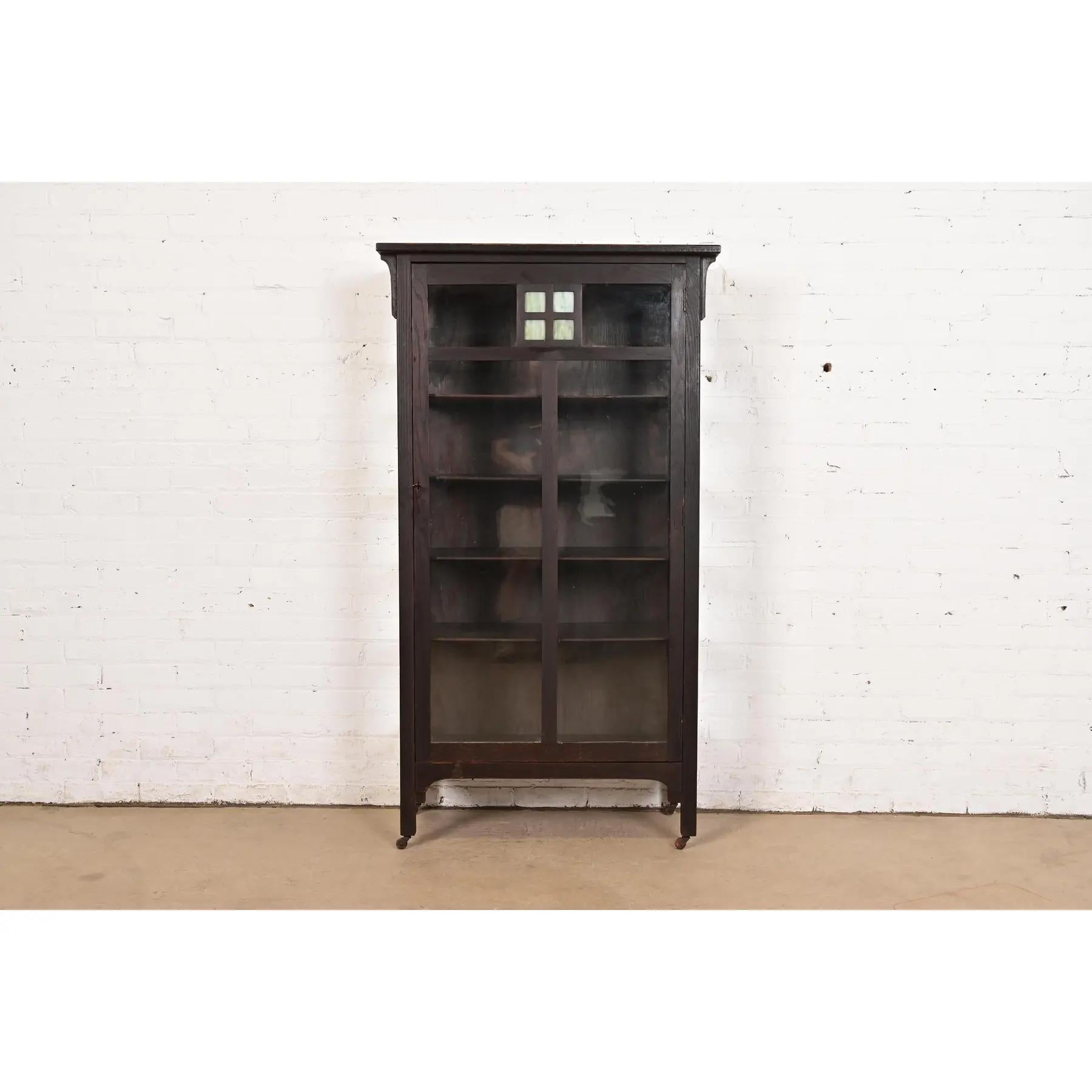 Una bellissima libreria o vetrina d'epoca Mission o Arts & Crafts

Alla maniera di Stickley Brothers

Di New England Furniture Co.

USA, circa 1900

Splendida quercia intagliata, con facciata e lati in vetro e pannelli in vetro colorato. L'armadio
