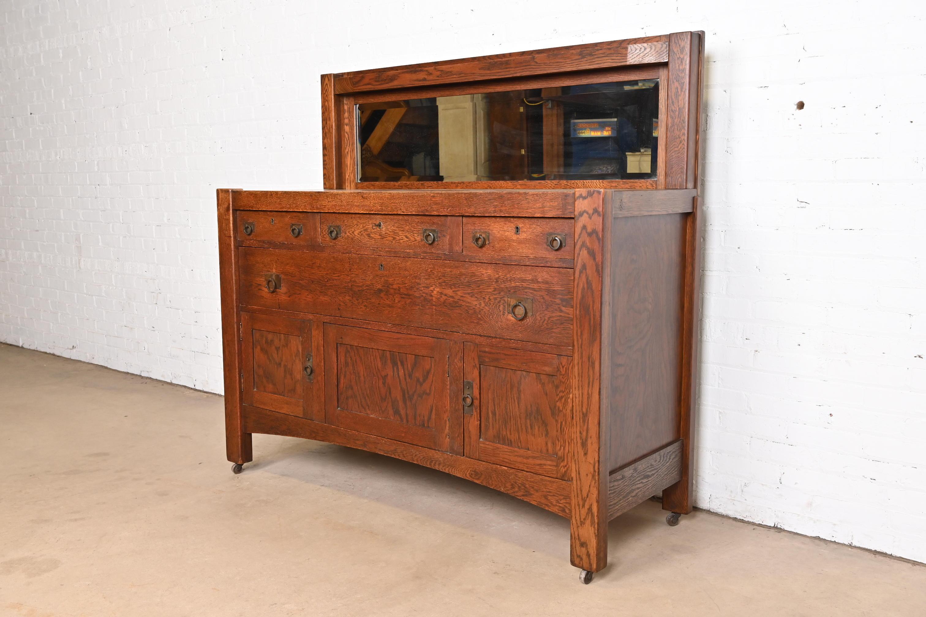 A gorgeous antique Mission or Arts & Crafts sideboard, buffet server, or bar cabinet

In the manner of Stickley Brothers

USA, Circa 1900

Oak, with mirrored backsplash, and original hammered copper hardware.

Measures: 60