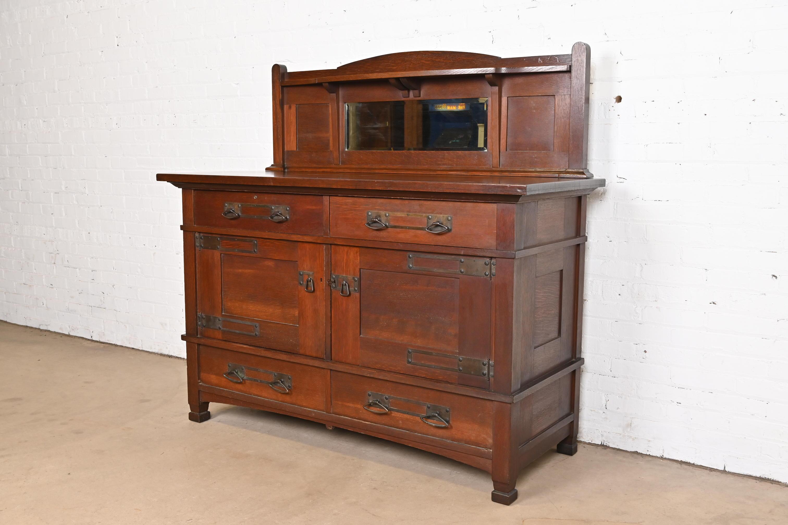 A gorgeous antique Mission or Arts & Crafts sideboard, buffet server, or bar cabinet

In the manner of Stickley Brothers

USA, Circa 1900

Quarter sawn oak, with mirrored backsplash, and original hammered copper hardware.

Measures: 60