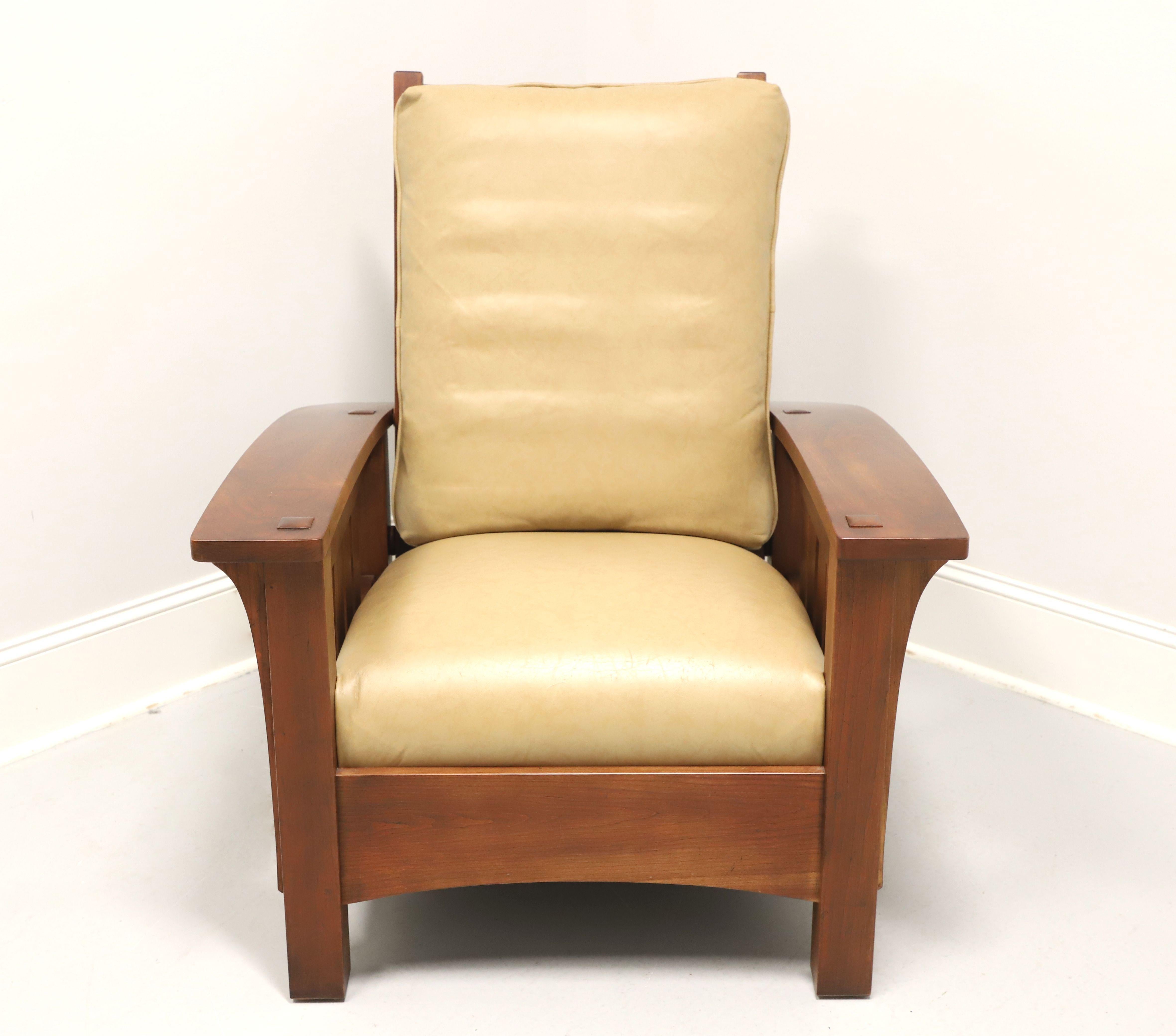 An Arts & Crafts Mission style reclining armchair by Stickley Furniture, their Morris. Solid cherry wood, adjustable reclining slatted high back, bowed arms supported by elongated corbels, slatted sides, and square straight legs. Features tan color