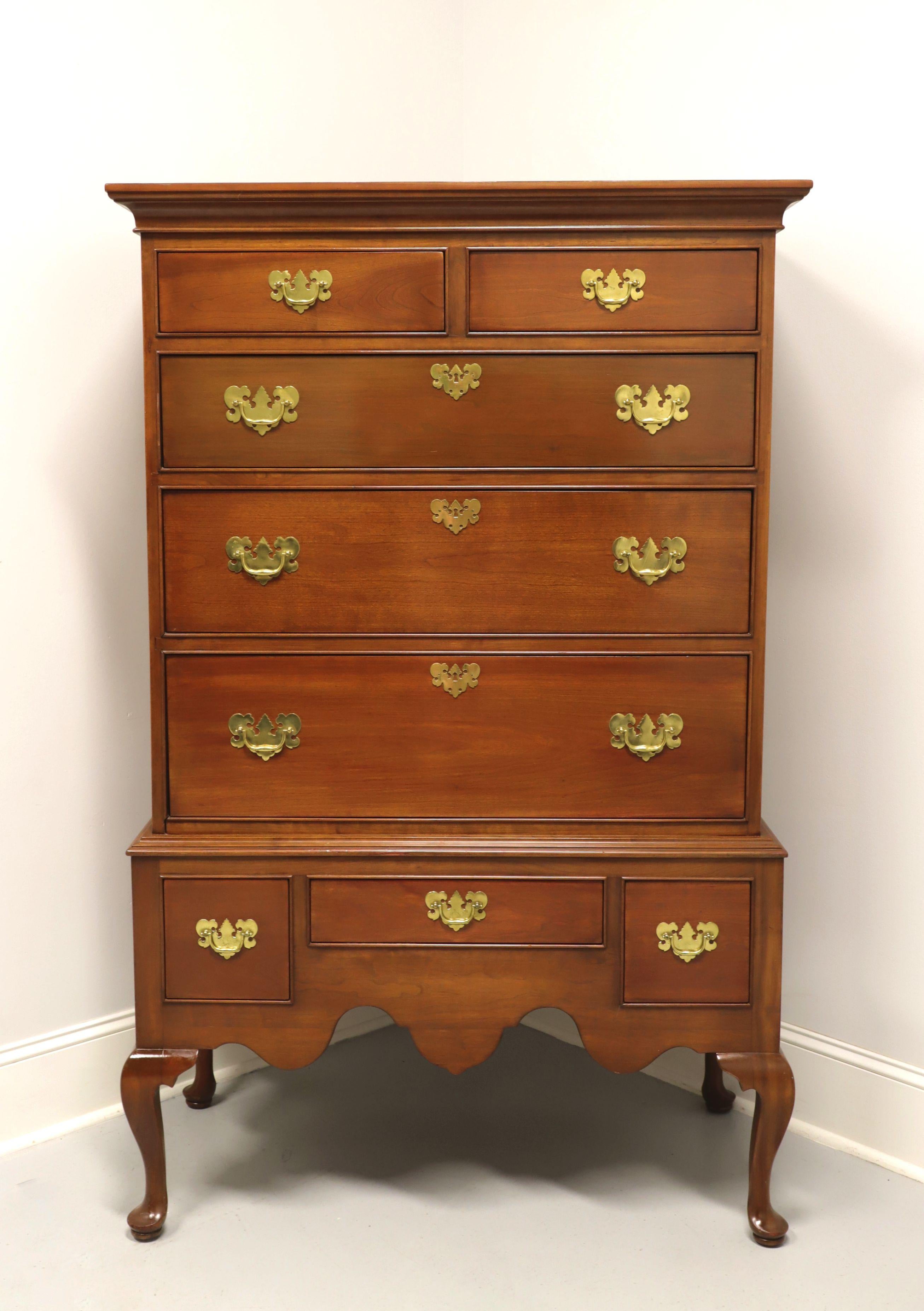 A Queen Anne style highboy chest by Stickley Furniture, a Leopold Stickley original. Solid cherry with brass hardware, crown molding at top, chest on chest styling, cabriole legs and pad feet. Features eight various size drawers of dovetail