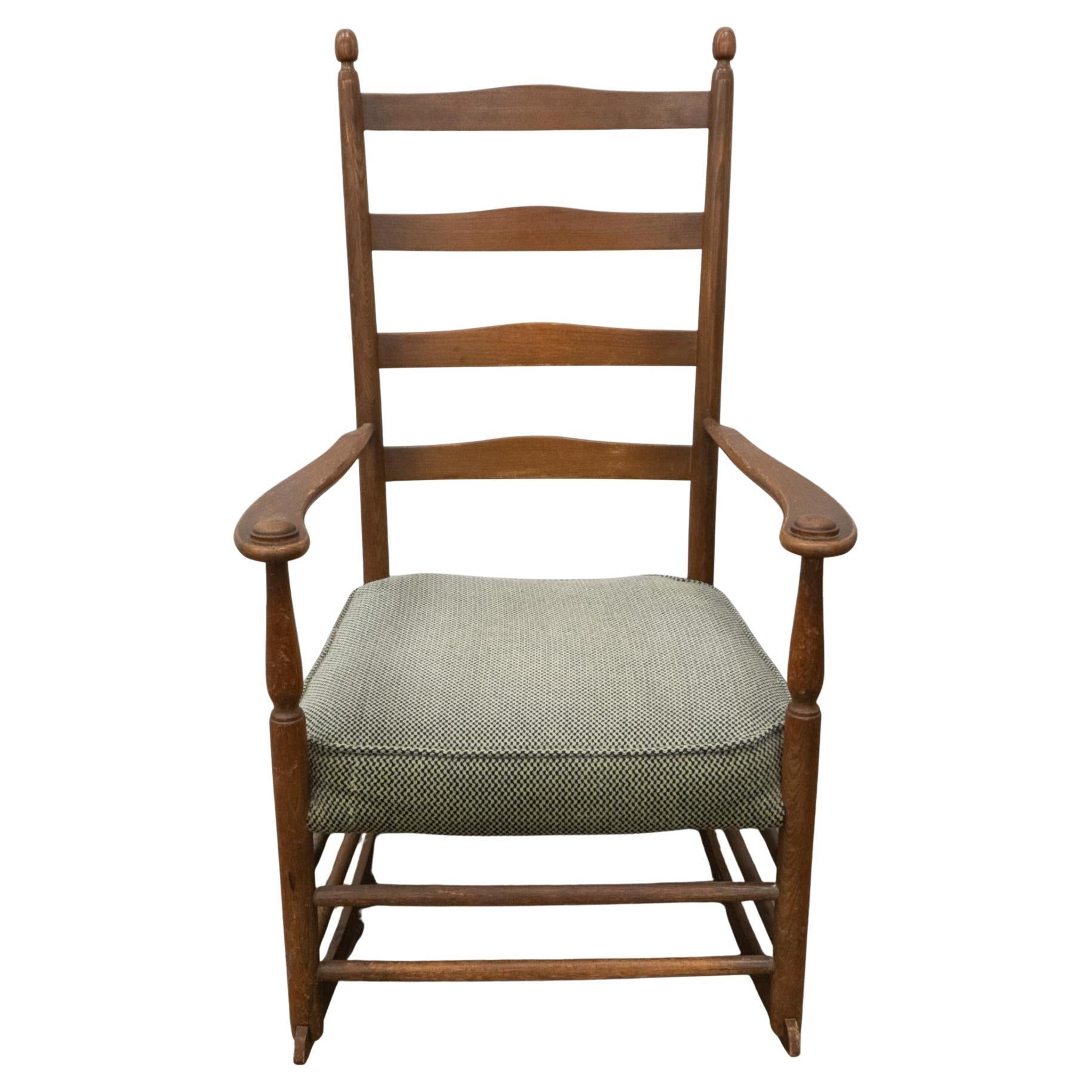 1910 Stickley Co.  Dondolo con schienale a scaletta in castagno in stile Shakers. Materiale Castagno con rivestimento in velluto di cotone.  Finitura originale con cuscini per la seduta Rivestiti in modo da riprodurre fedelmente il tessuto originale