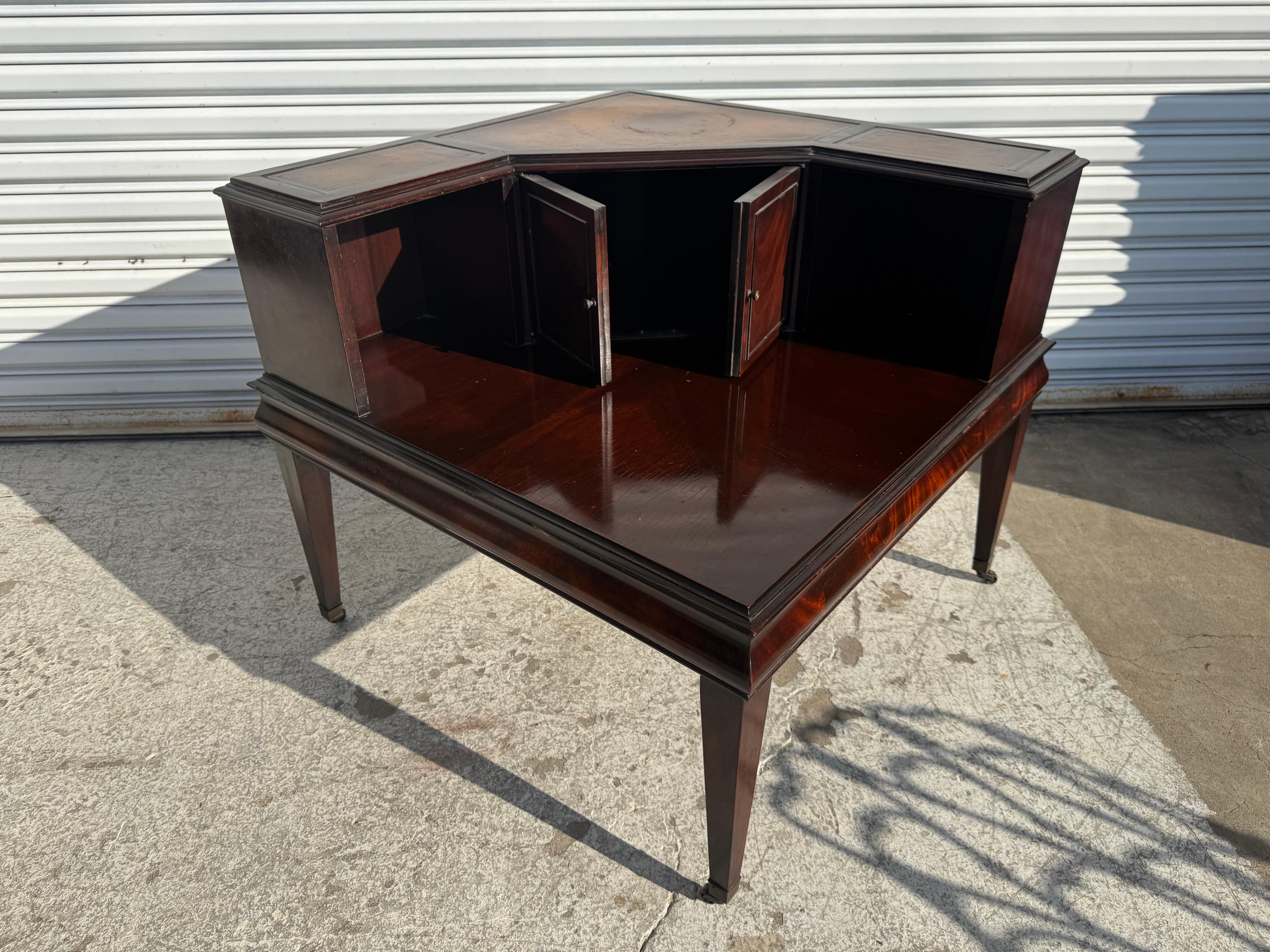 Il s'agit d'une belle table d'appoint d'angle de Stickley Furniture.
La table a son plateau en cuir d'origine et repose sur des roulettes en laiton.
La table est dotée de deux portes qui révèlent l'espace de rangement lorsqu'elles sont ouvertes.
Il