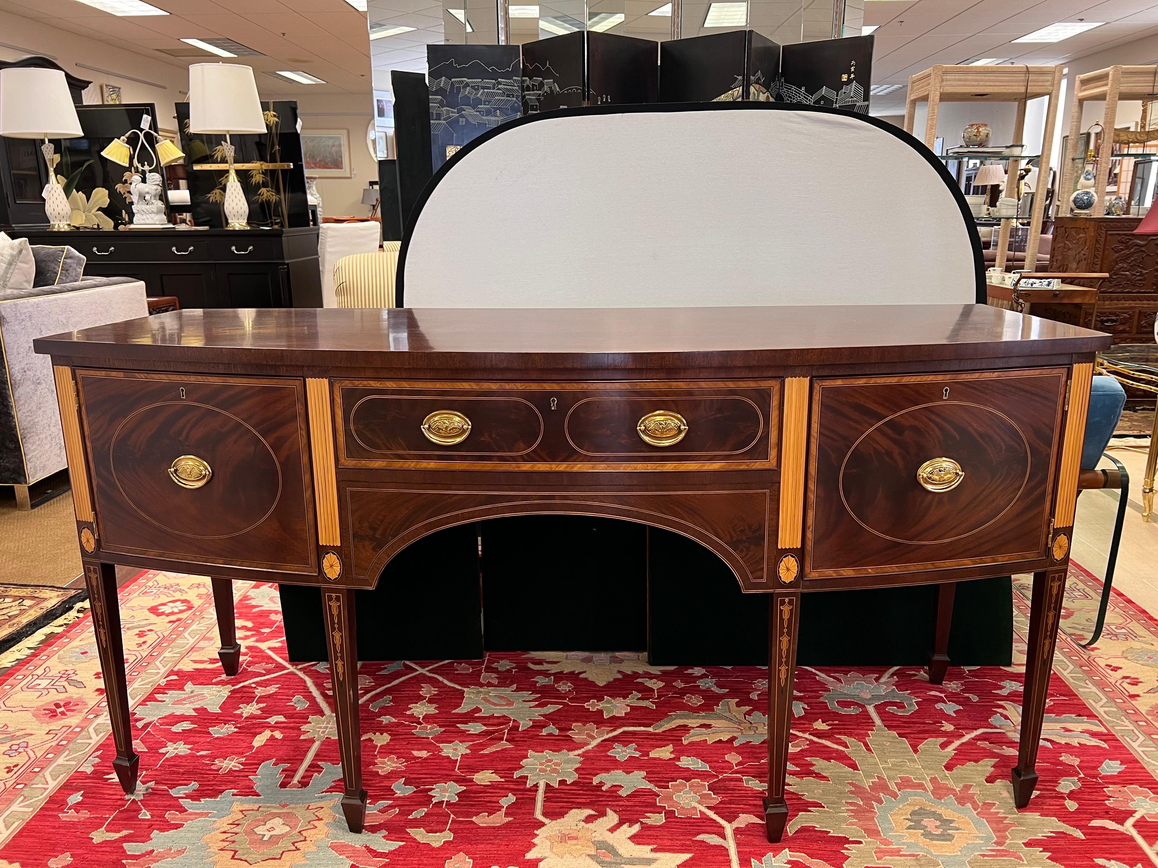 Elegant Stickley inlaid mahogany buffet from the Colonial Williamsburg Collection.  Features stunning bell flower and oval inlay on tapered legs.
Sides have star inlay. It has two locking flame mahogany doors that open to storage and one locking