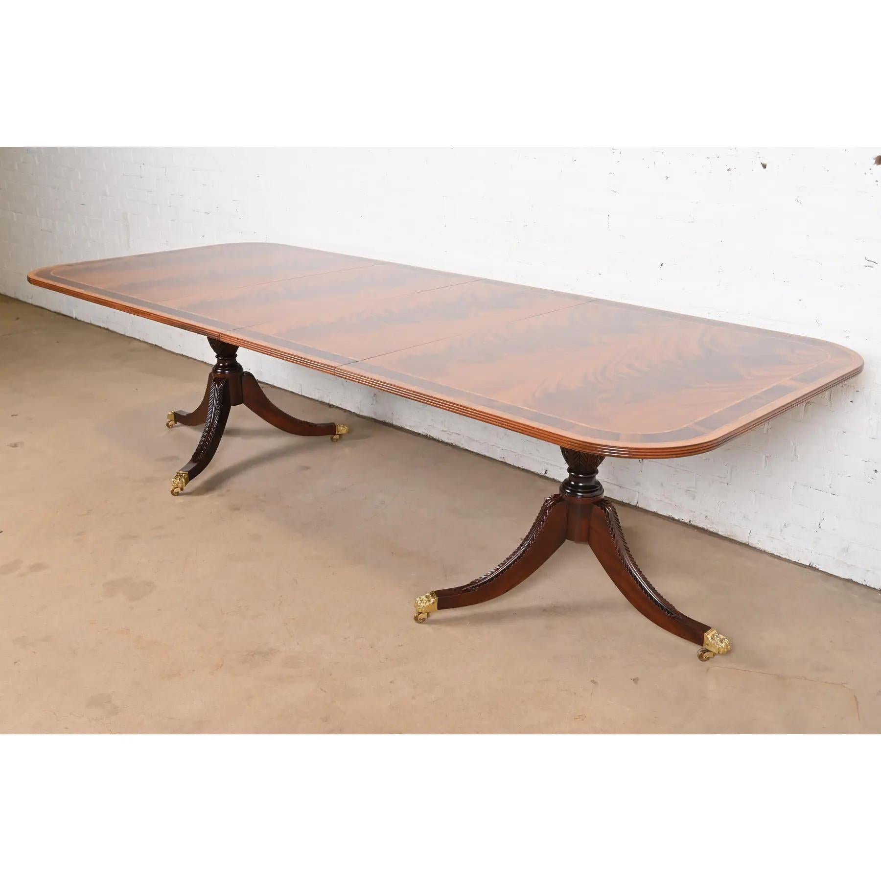 Exceptionnelle table à manger à rallonge à double piédestal de style Géorgien ou Régence.

Par Stickley

USA, Circa Late 20th Century

Magnifique plateau en acajou flammé assorti aux livres, avec bandes en bois satiné, piédestaux en acajou massif
