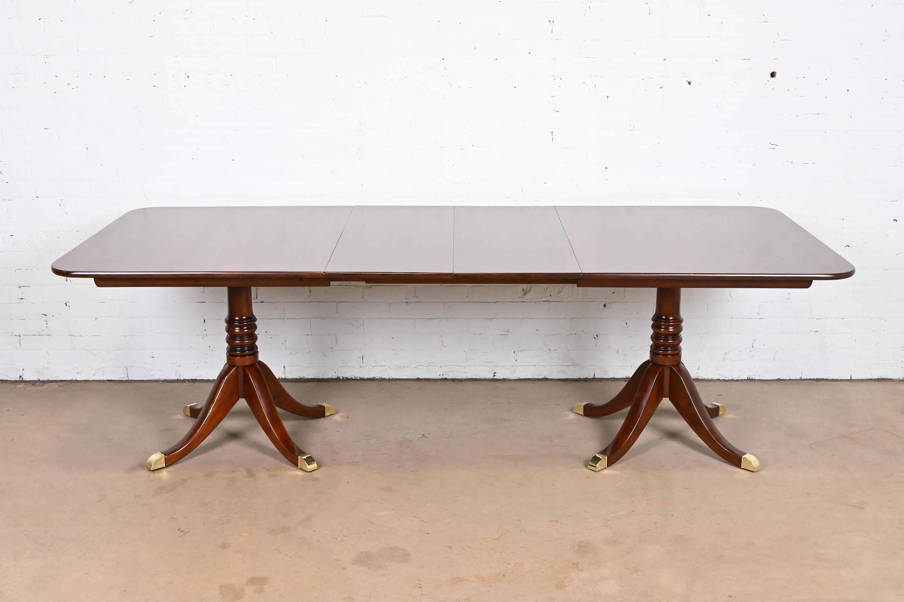An exceptional Georgian or Regency style double pedestal extension dining table

By L &J.G. Stickley

USA, Mid-20th Century

Carved solid cherry wood, with brass-capped feet.

Measures: 66.5