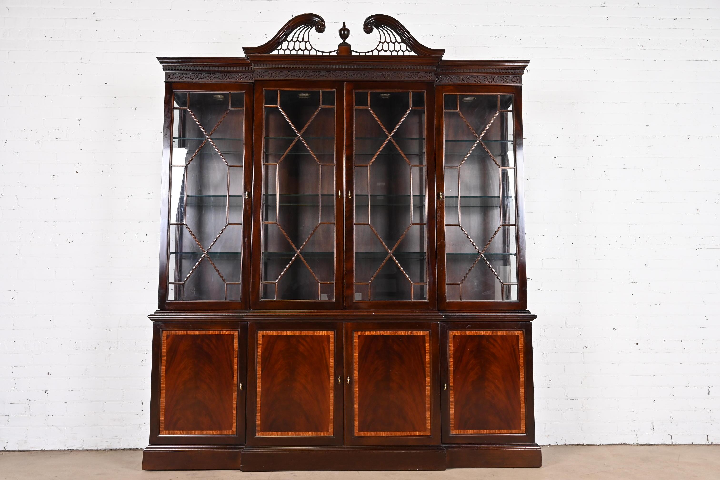 A beautiful Georgian or Chippendale style lighted breakfront bookcase cabinet or dining cabinet

By L. & J.G. Stickley

USA, Circa 1980s

Carved flame mahogany, with satinwood banding, glass front doors, and original brass hardware.

Measures: 78