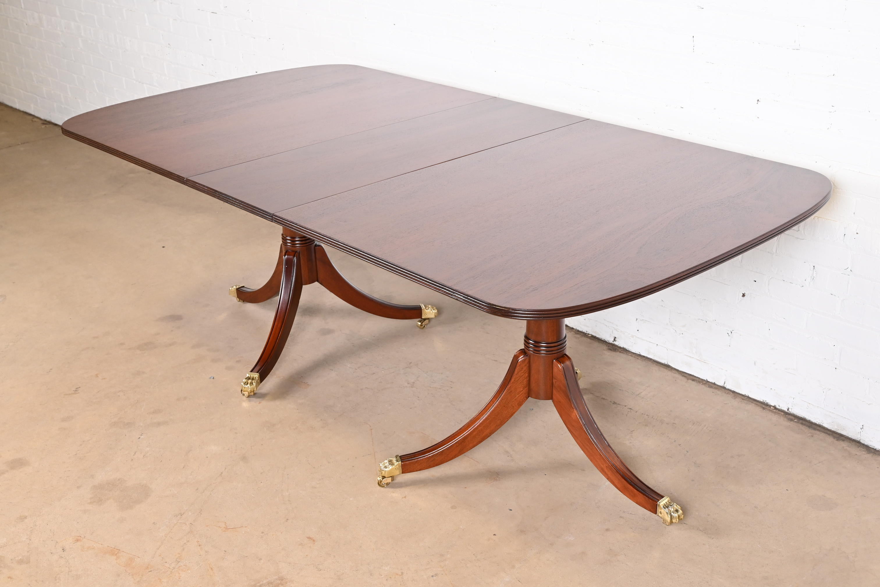 A gorgeous Georgian or Regency style double pedestal extension dining table

By Stickley

USA, Late 20th century

Carved mahogany, with brass-capped paw feet and castors.

Measures: 68.25