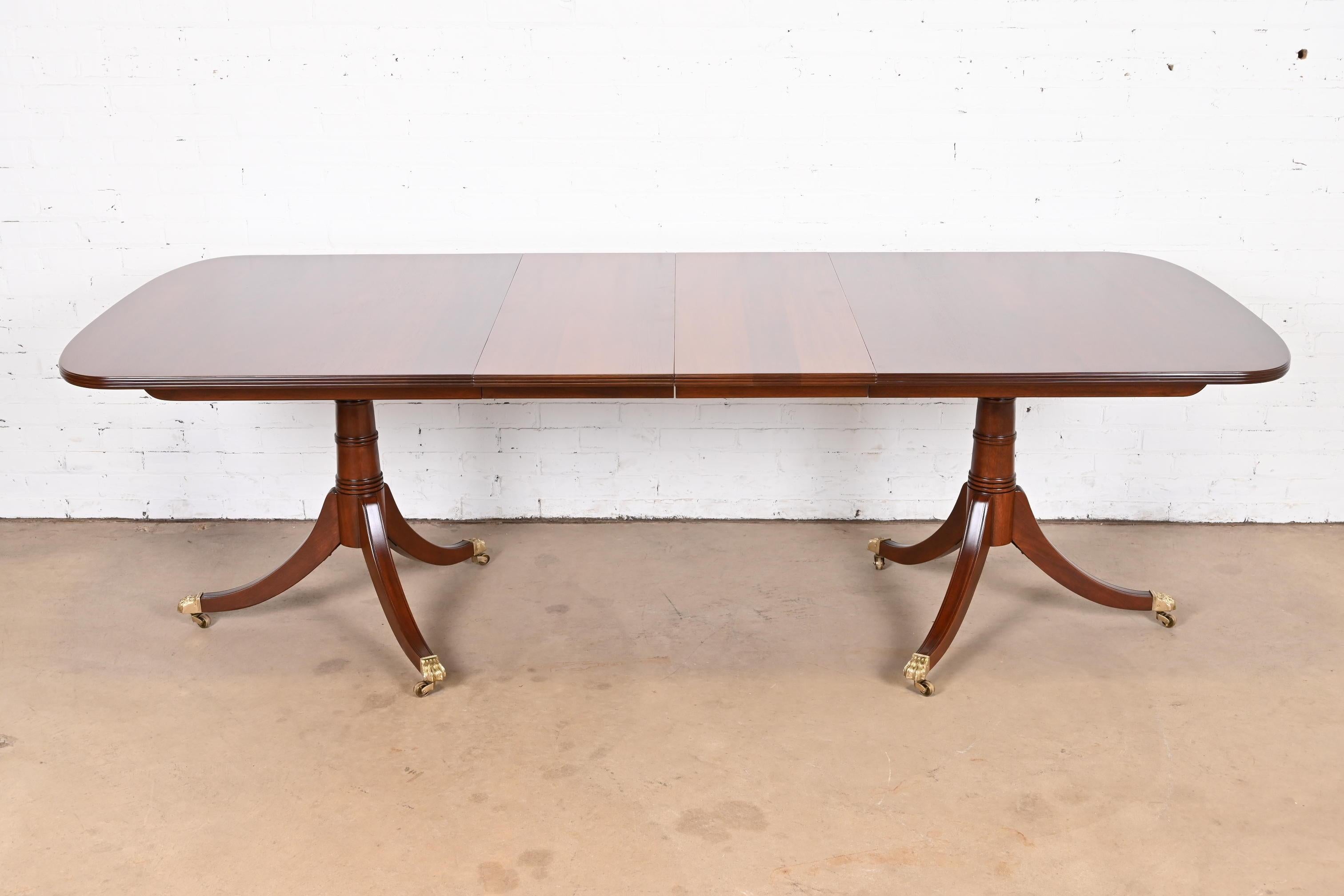 An exceptional Georgian or Regency style double pedestal extension dining table

By Stickley

USA, Late 20th Century

Beautiful solid mahogany, with carved pedestals, and brass paw feet on brass casters.

Measures: 68.25
