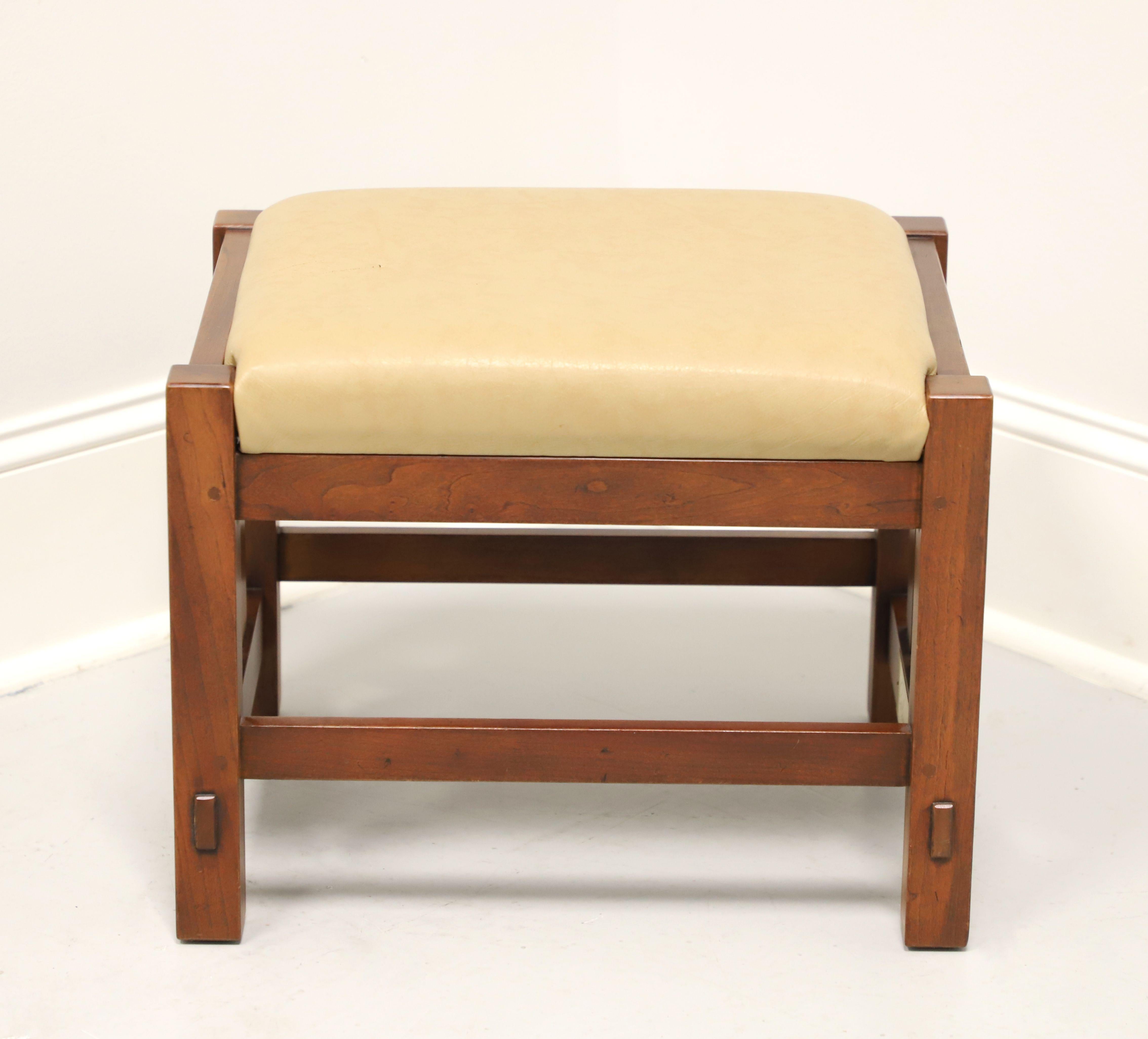 An Arts & Crafts Mission style footstool by Stickley Furniture. Solid cherry wood, tan color leather upholstered seat, slatted sides, stretchers, and square straight legs. Made in Manilas, New York, USA, circa 1996.

Style #: 