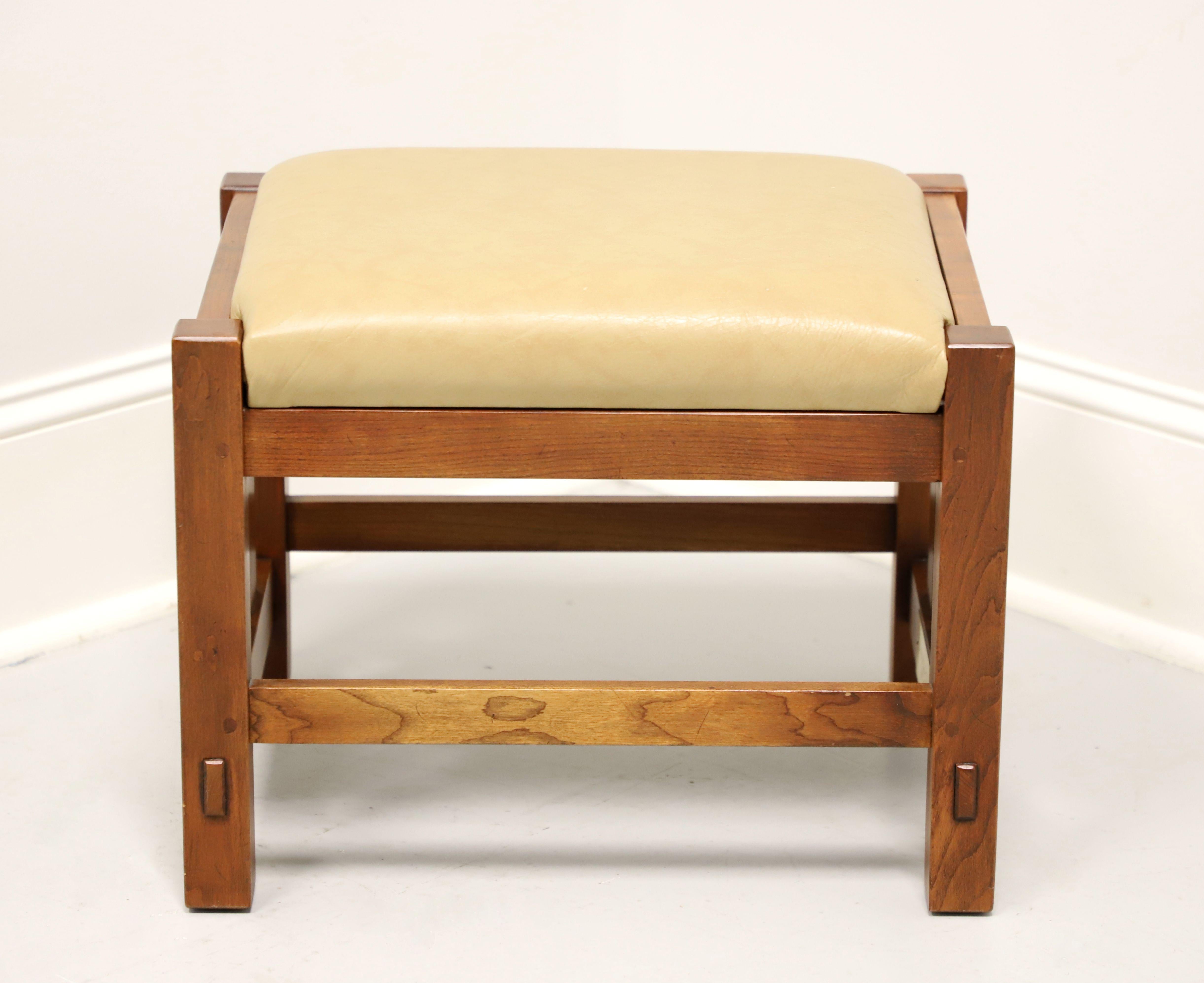 An Arts & Crafts Mission style footstool by Stickley Furniture. Solid cherry wood, tan color leather upholstered seat, slatted sides, stretchers, and square straight legs. Made in Manilas, New York, USA, circa 1996.

Style #: 