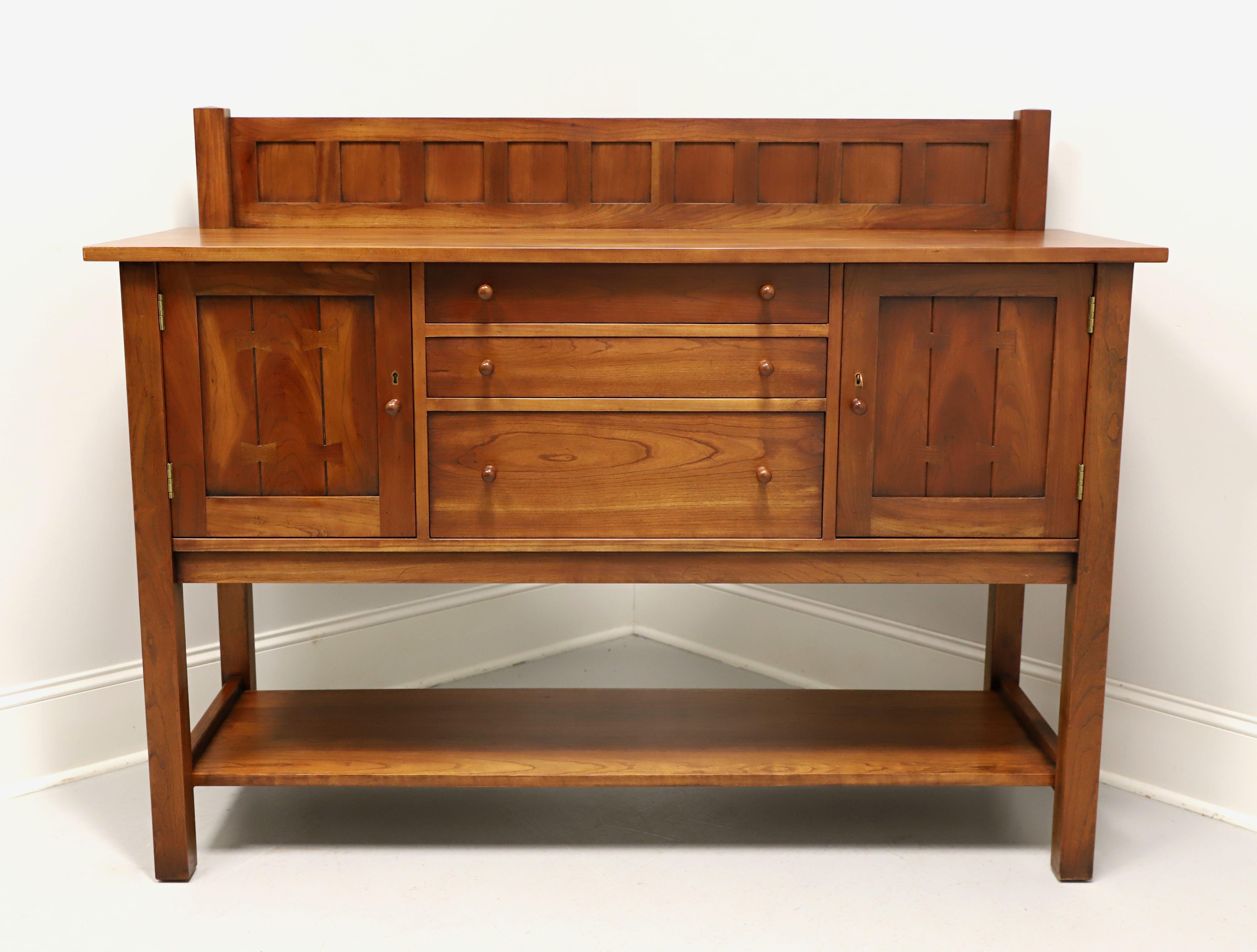 A Mission style sideboard by Stickley Furniture, from their Mission Collection. Solid cherry wood, brass hinge & lock hardware, square edge top with a plate groove in front of the decorative back gallery, cherry knobs to drawers & doors, butterfly