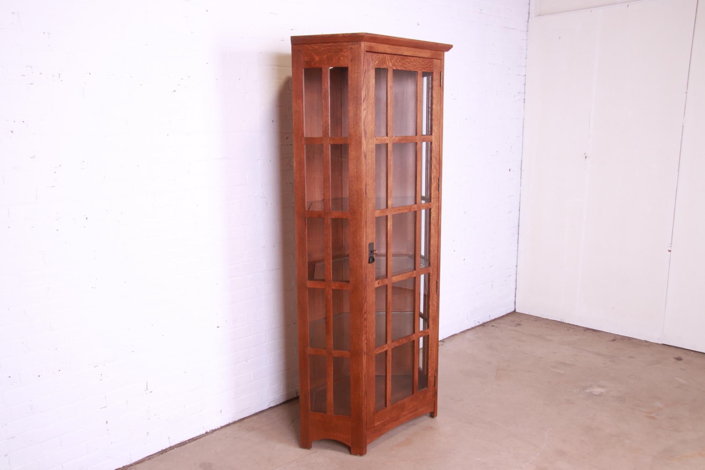An exceptional Mission Arts & Crafts style lighted corner display cabinet

By Stickley

USA, 2000

Solid oak, with mullioned glass door and glass shelves.

Measures: 38.75