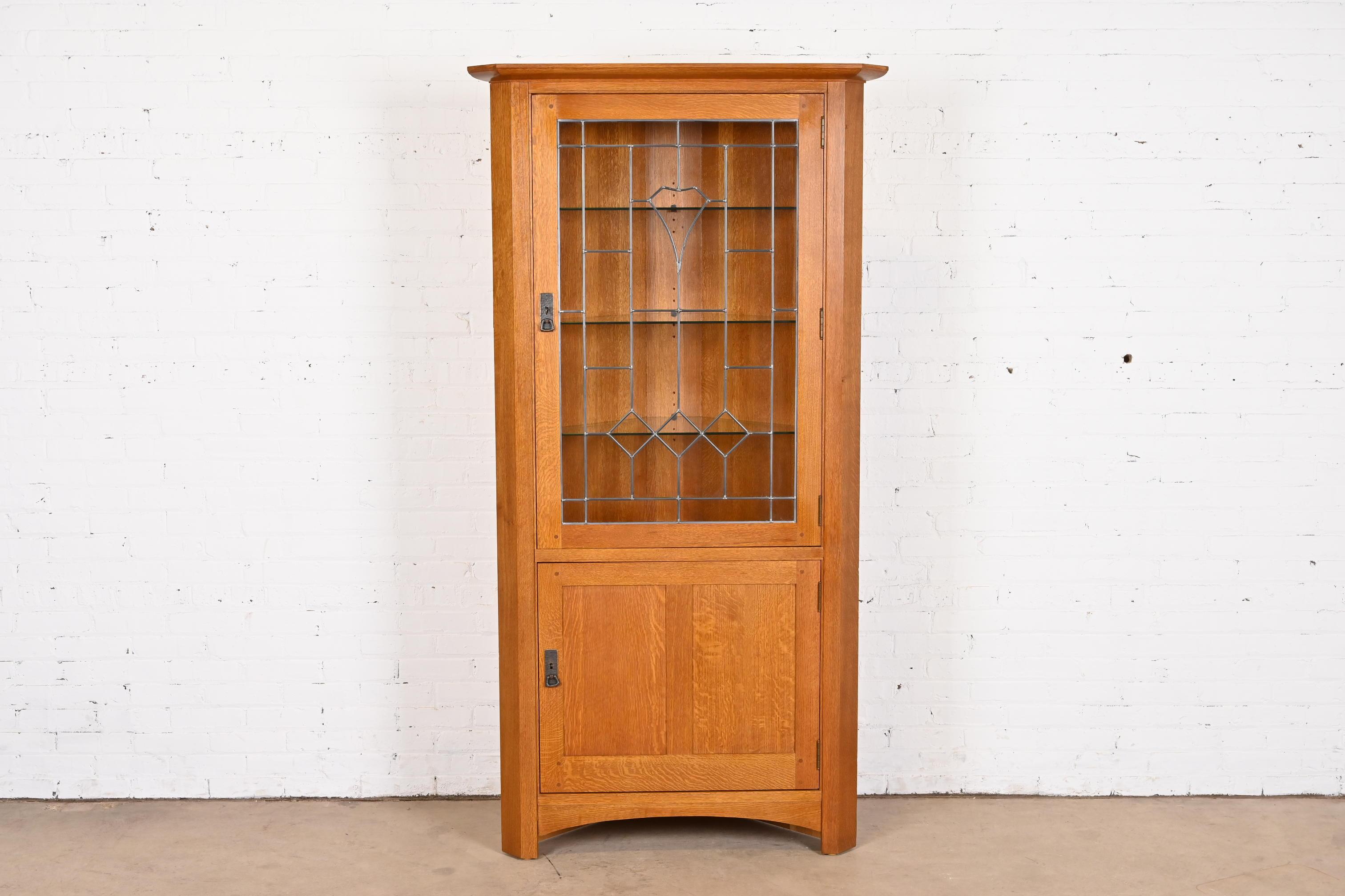 An exceptional Mission or Arts & Crafts style lighted corner cupboard or display cabinet

By Stickley

USA, Circa Late 20th Century

Solid oak, with leaded glass door, and hammered copper hardware.

Measures: 36