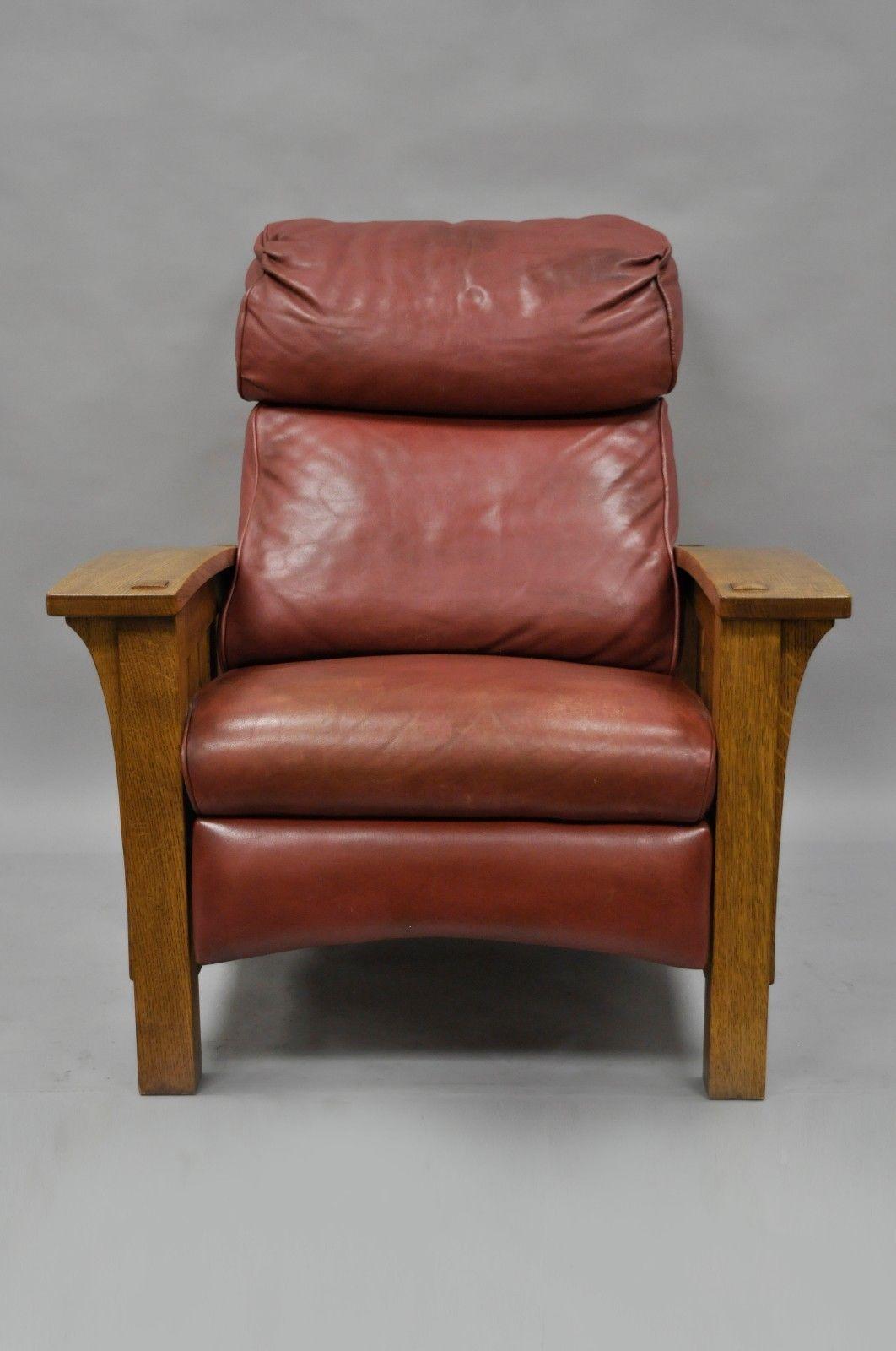 Stickley mission solid oak bustle back recliner lounge chair. Item features solid oak wood frame, long curved armrests, slat sides, and straight square legs. The bustle back cushion, seat cushion, and reclining footrest are upholstered in a