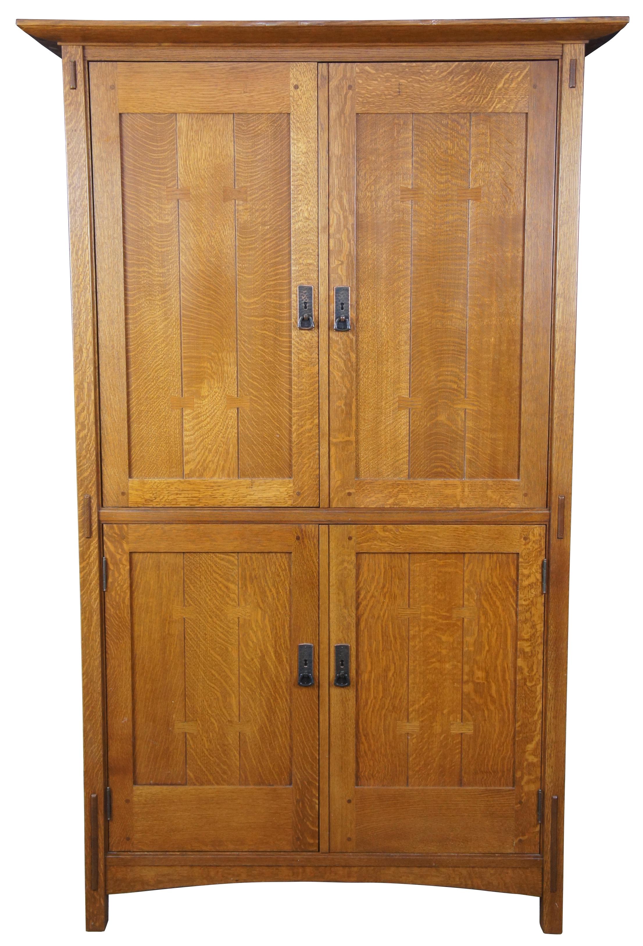 Late 20th century Stickley media cabinet or armoire. Made from quartersawn oak in Classic mission design with hammered copper hardware, bowtie inlay and 2 fitted interior drawers.
  