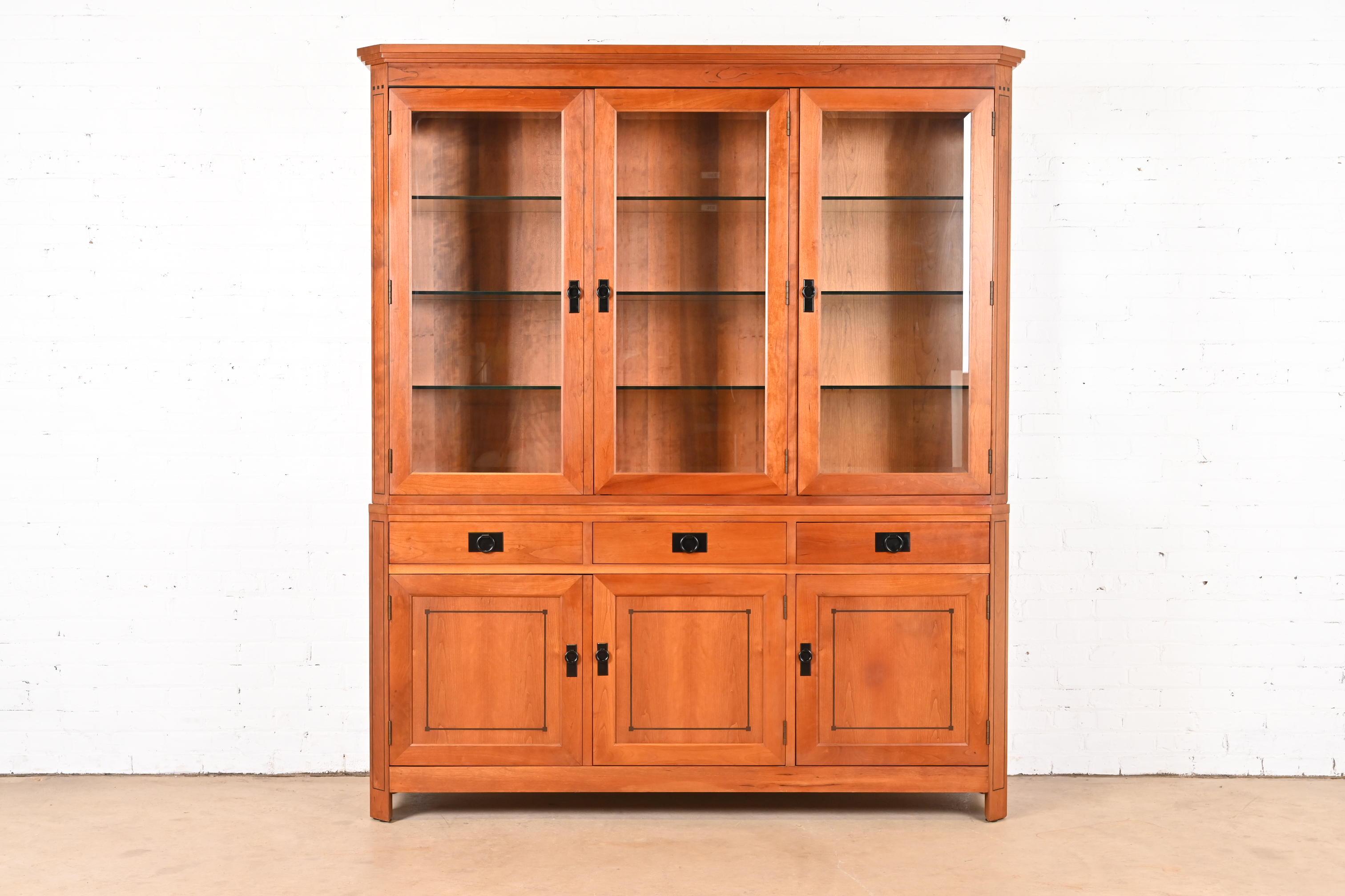 A beautiful Arts and Crafts or Shaker style lighted breakfront bookcase cabinet or china cabinet

By L. & J.G. Stickley (labels present)

USA, 2000

Cherry wood, with beveled glass front doors and side panes, and original hardware.

Measures: 70.5