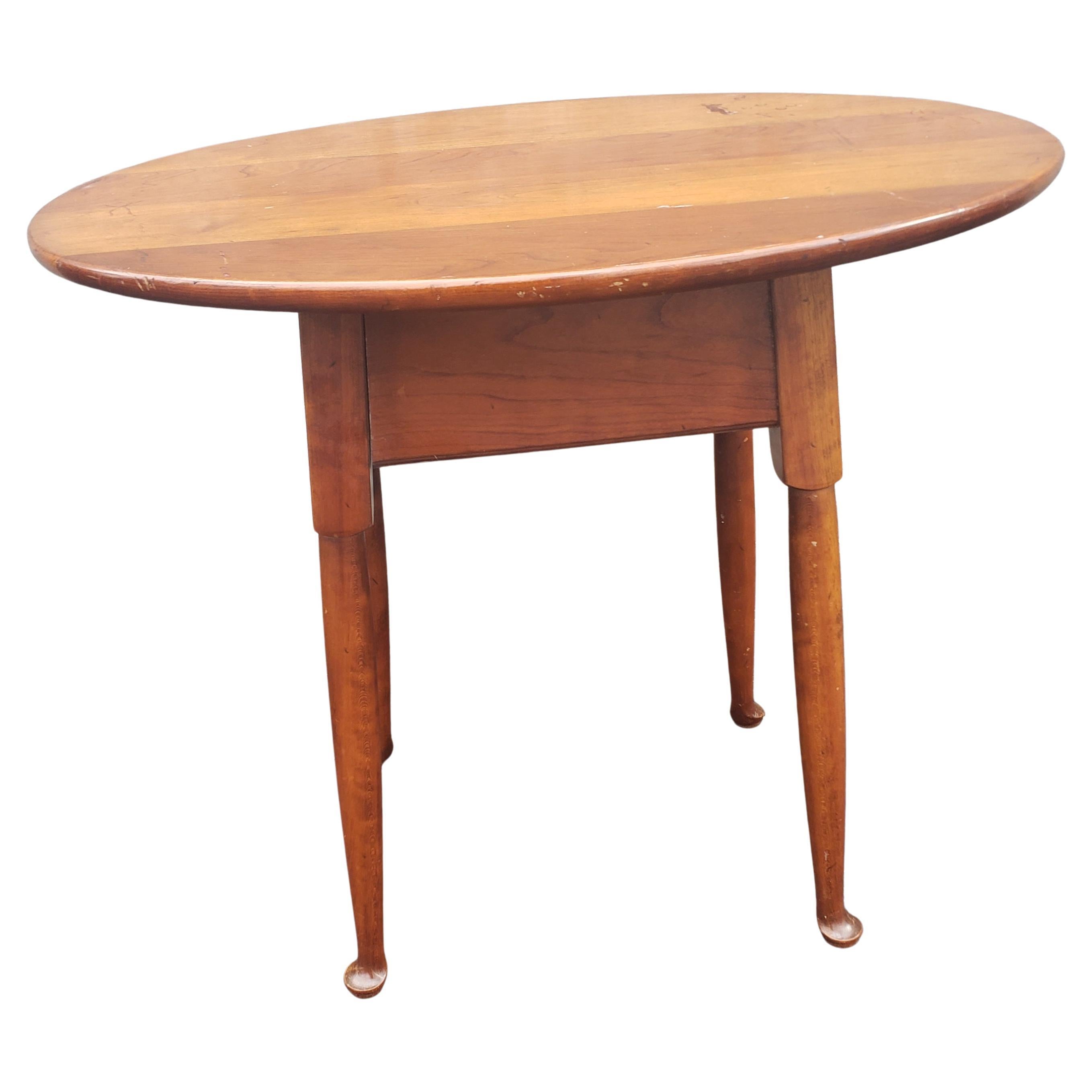 A midcentury Stickley single drawer Cherry oval side table measuring 25.5