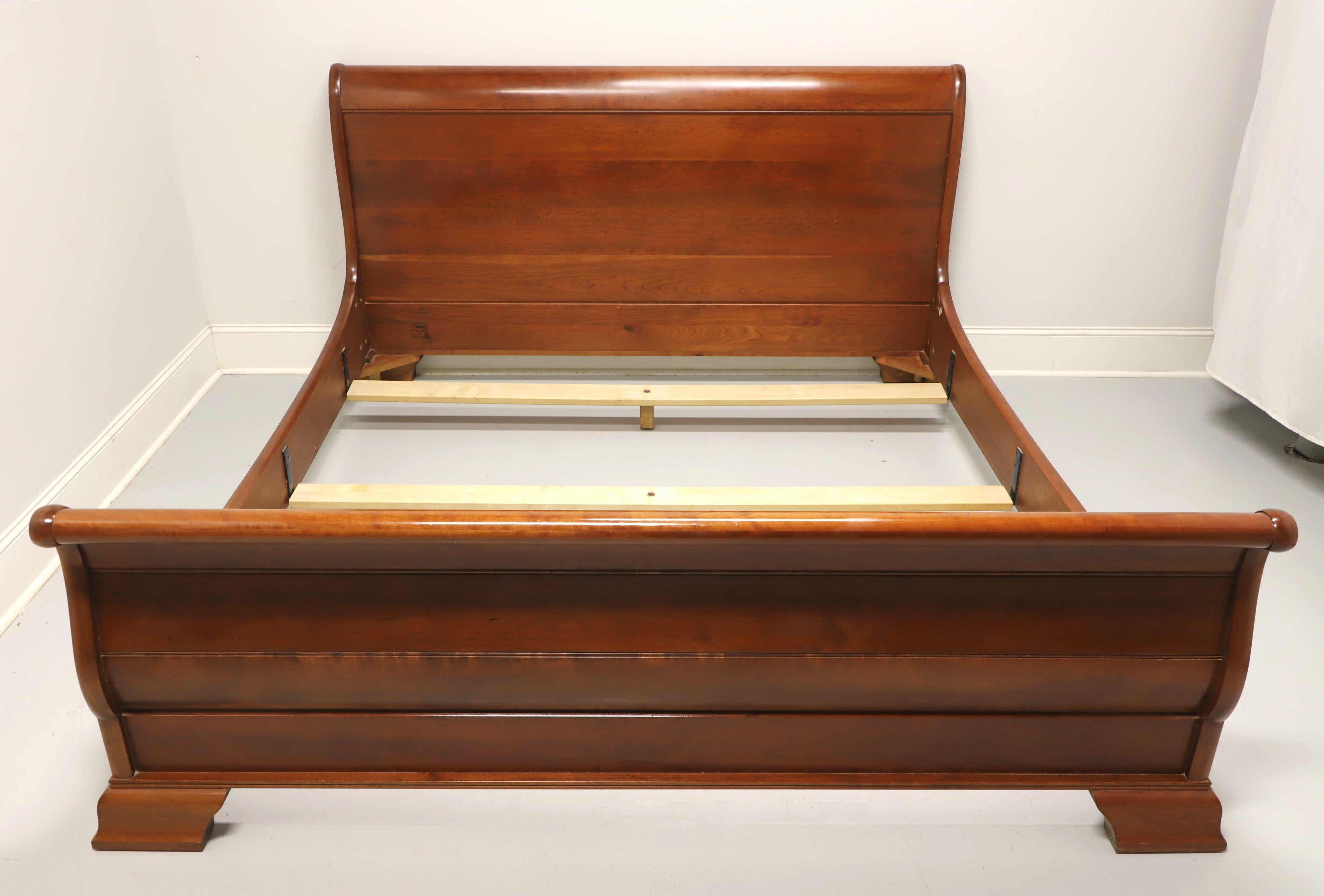 An American Empire style king size sleigh bed by Stickley Furniture. Solid cherry headboard, footboard, and bolt held side rails. Includes three center supported slats for mattress support. Made in the USA, circa 2001.

Style #: 3037L

Measures: