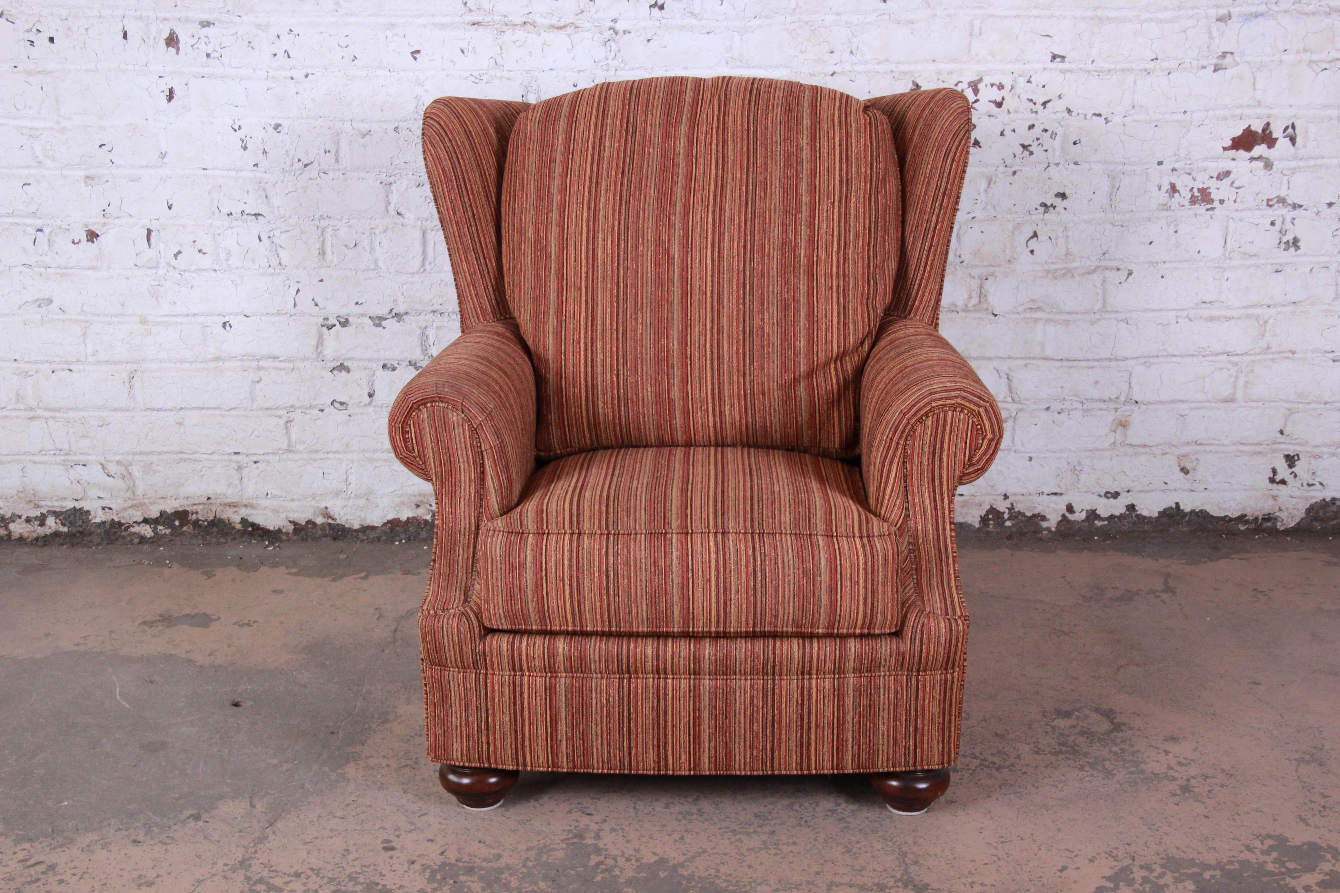 A gorgeous contemporary wingback lounge chair by Stickley. The chair features beautiful orange striped upholstery and a nice traditional style. It is very well made, as expected from Stickley. The original label is present. The chair is in excellent