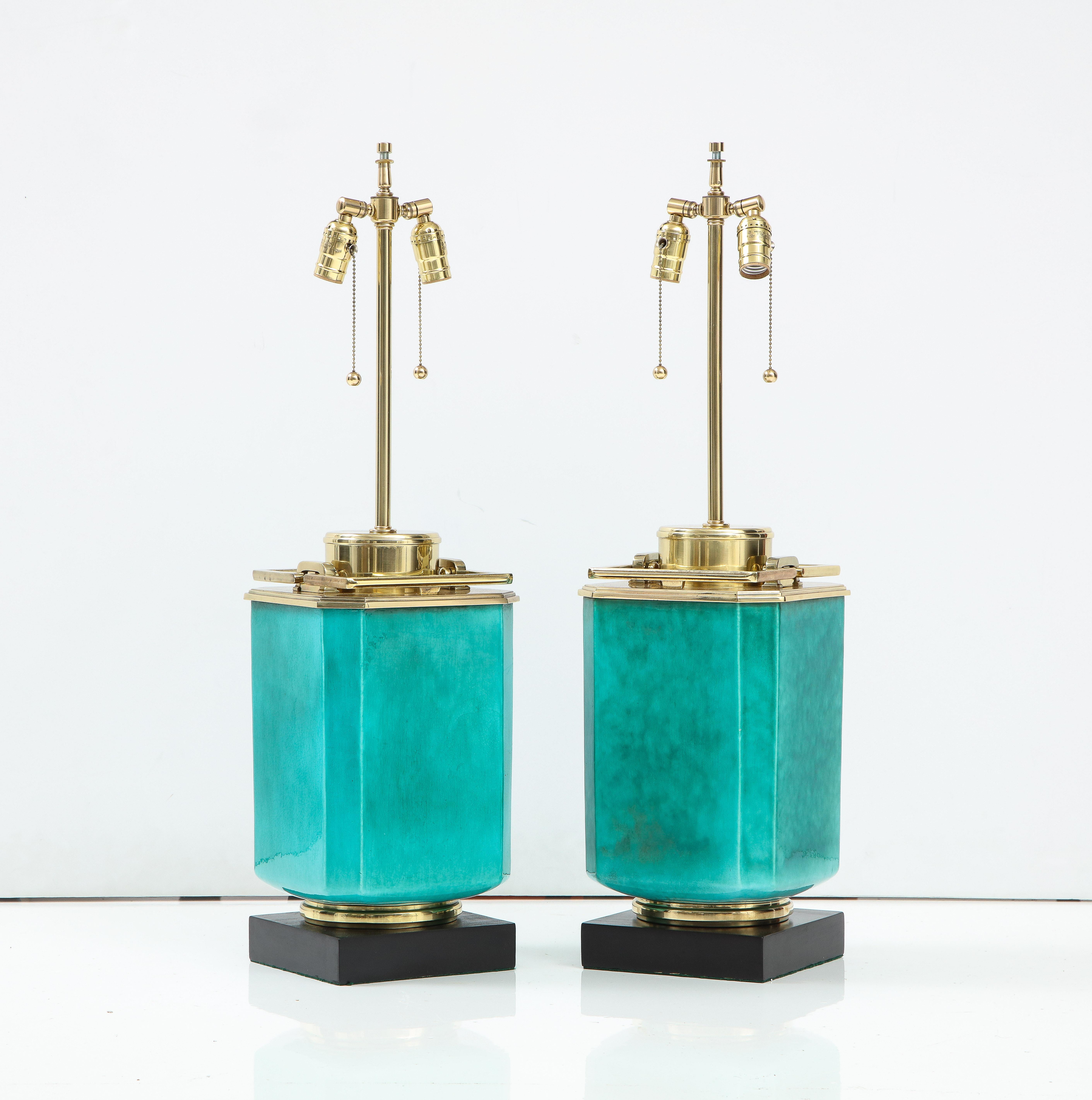 Pair of impressive large scale porcelain lamps featuring an emerald green glaze body and heavy brass decorative elements. Lamps have been rewired for use in the USA using double cluster sockets, 75W max each socket. Meticulously restored.