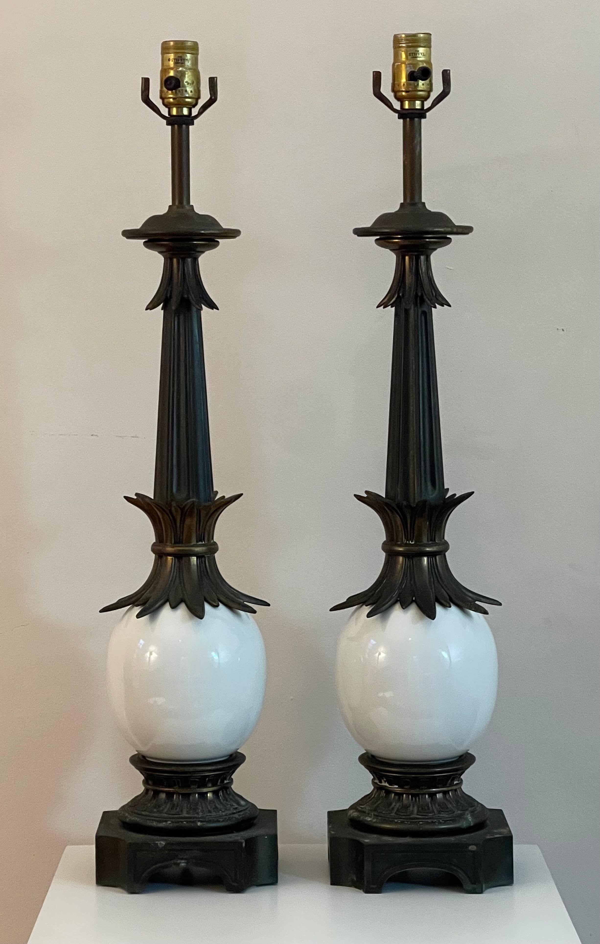 Chic pair of mid-century Stiffel lamps with iconic ostrich egg body. Handsome, dark bronze patina to brass ornamental elements and base.

