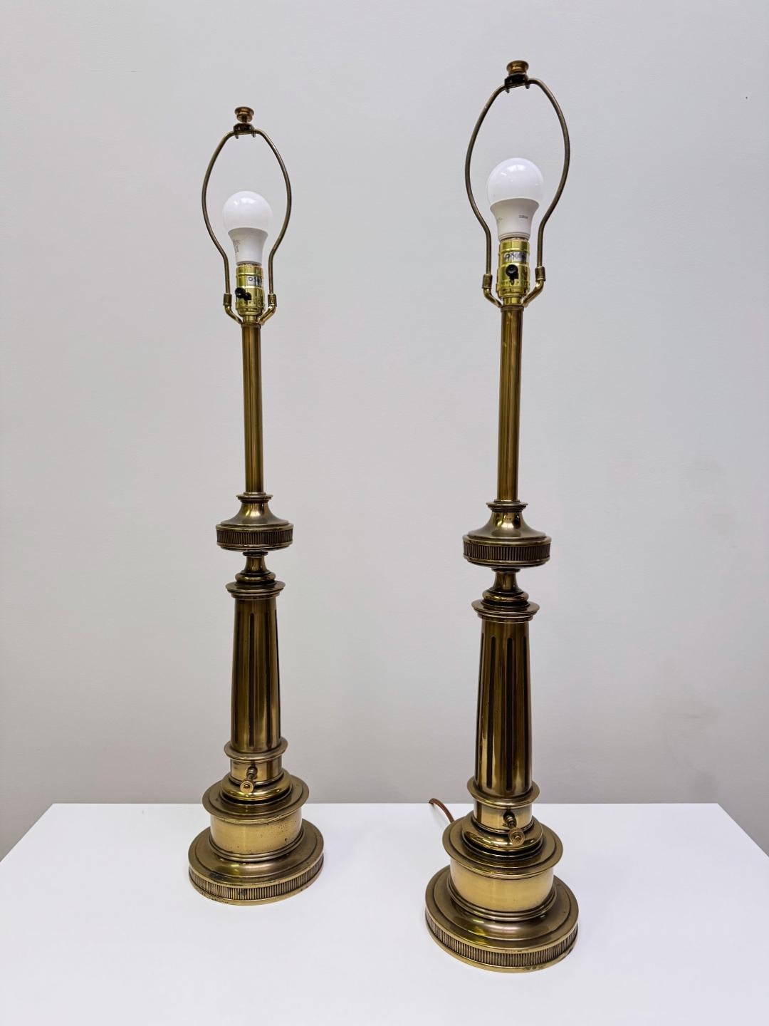Coppia di eleganti lampade da tavolo prodotte da Stiffel negli Stati Uniti. Le lampade sono realizzate in ottone massiccio patinato con paralumi originali. Le lampade sono in ottime condizioni. 
Perfettamente funzionante e testato. Una presa Edison