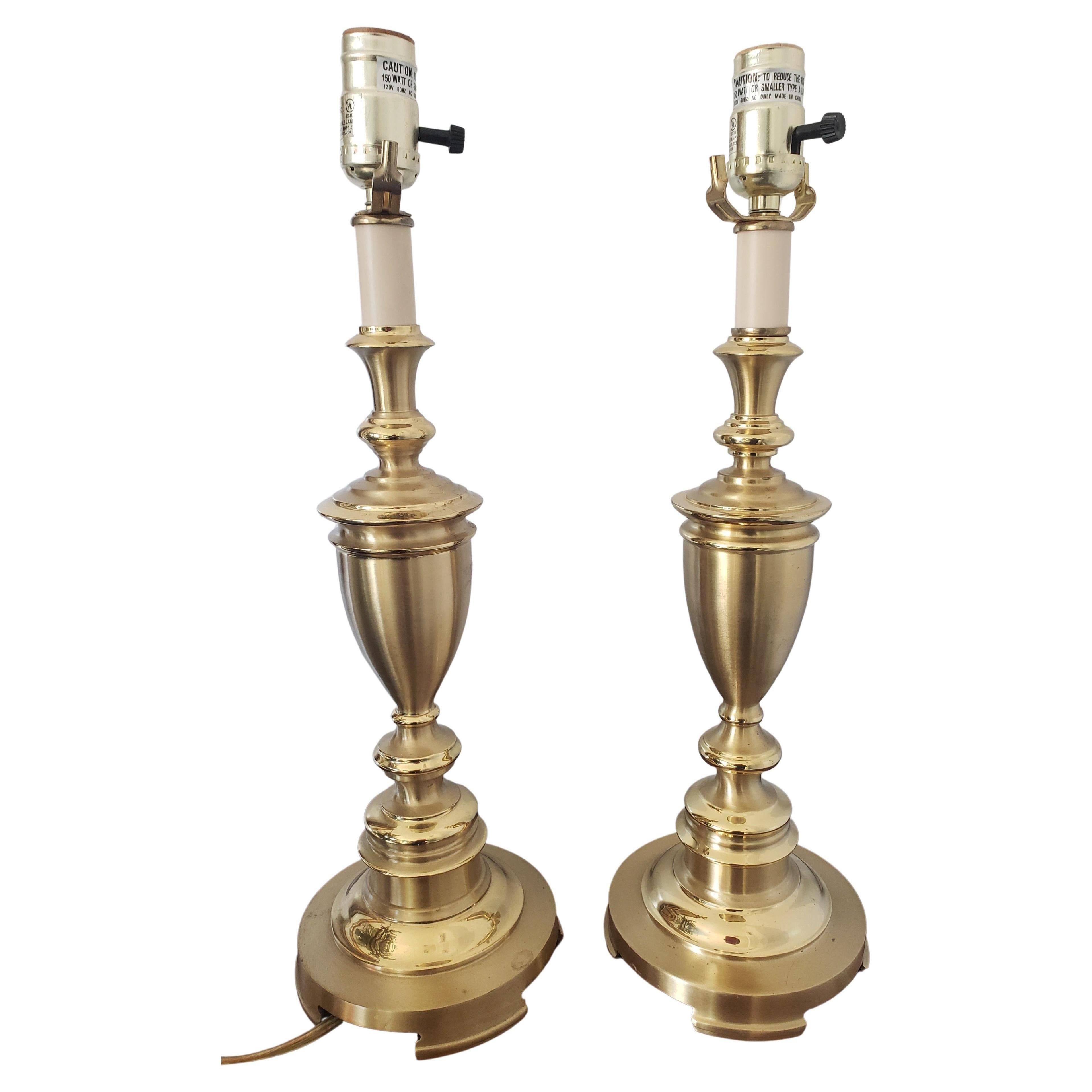 Stunning pair of solid brass trophy table lamps attributed to Stiffel. Very good condition. Medium size lamps perfect for small rooms and small areas. 
Measure 19