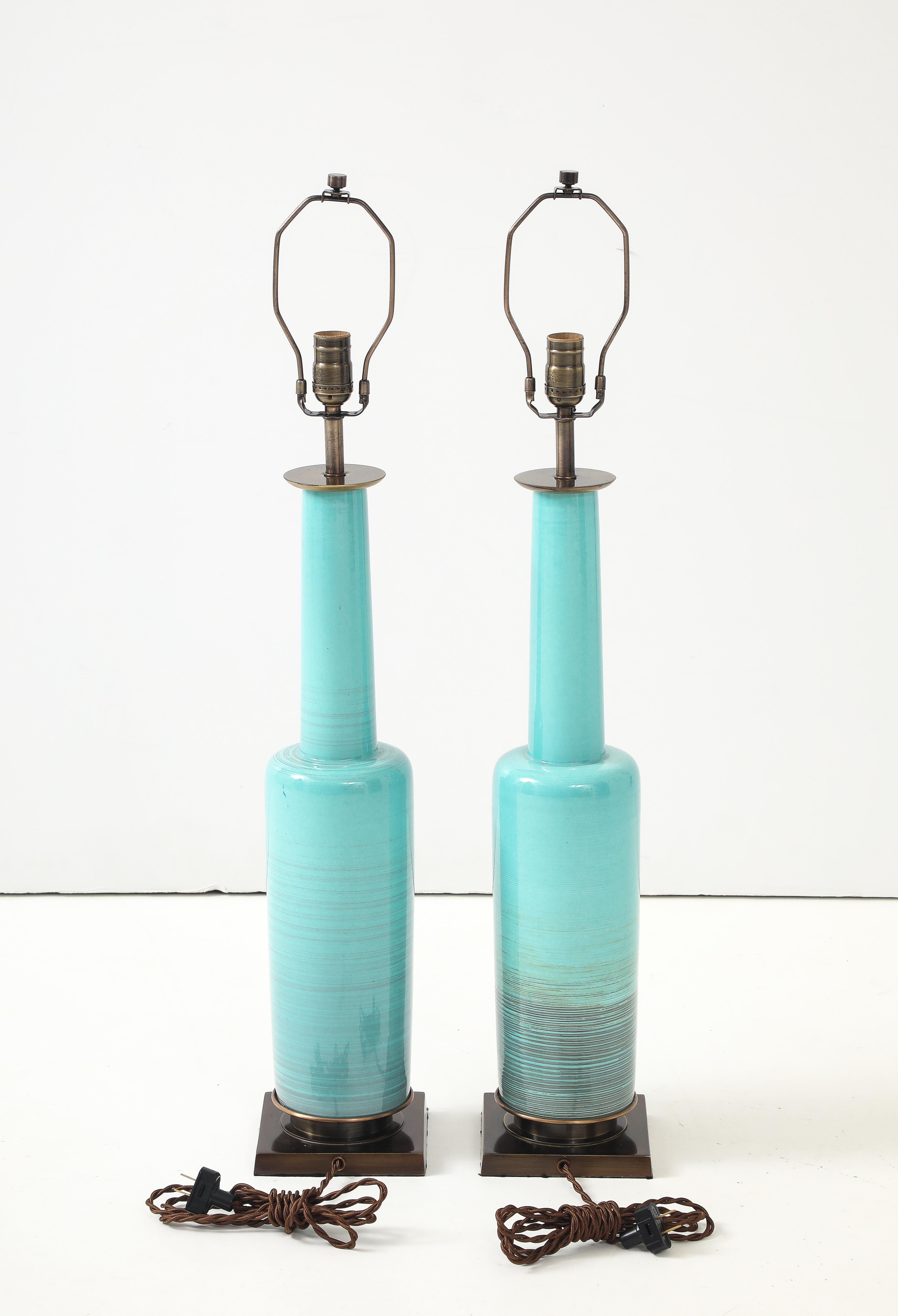 Pair of Turquoise clazed porcelain lamps with brown striations, mounted on aged brass/bronze bases. Professionally rewired for use in USA.