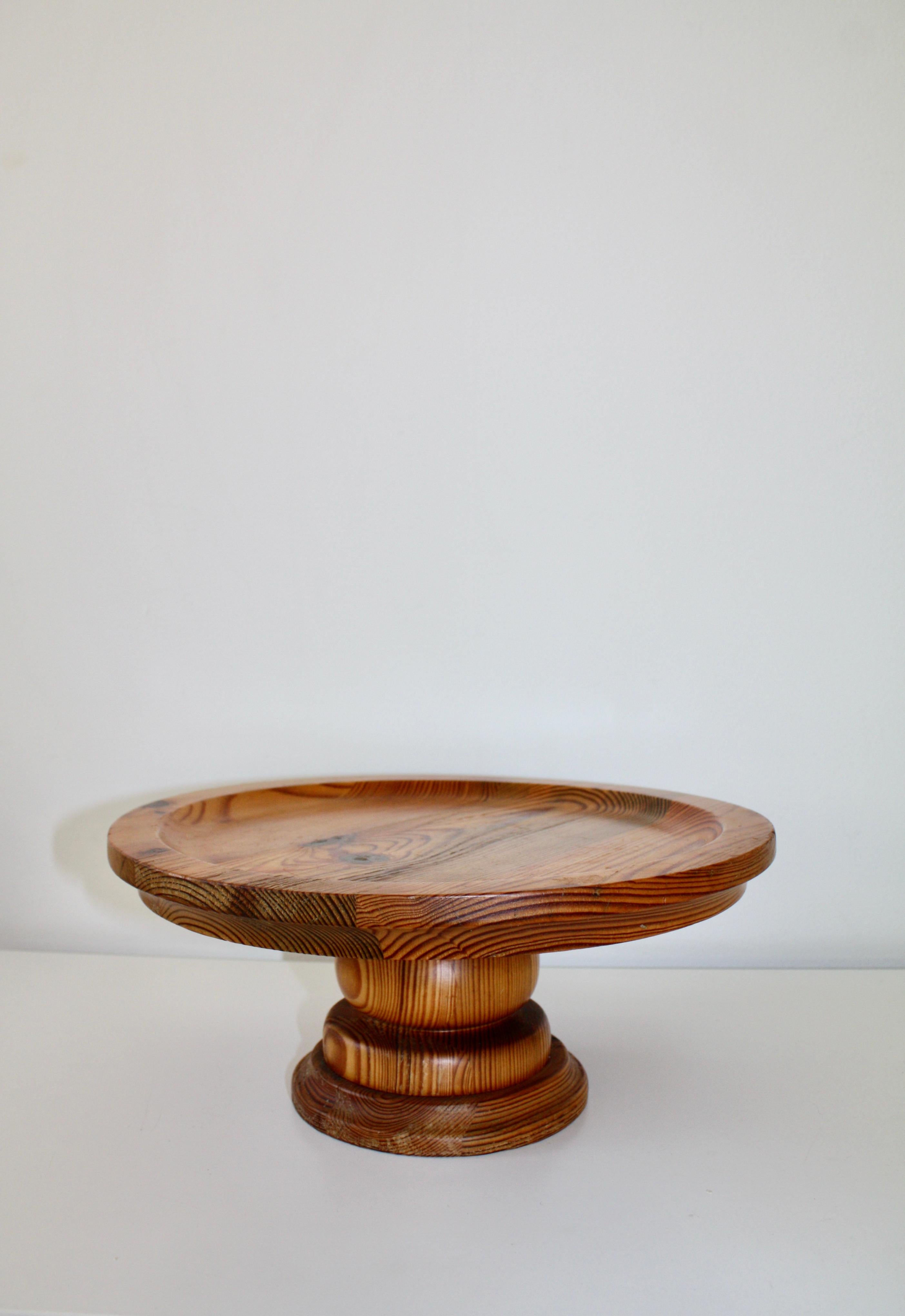 Gran plato/plato para tartas de madera maciza de pino sueco moderno de mediados de siglo. Diseñado por Stig Johnsson y fabricado por Smålandsslöjd, en la pequeña ciudad sueca de Värnamo, en los años 1960/70.  
Gran plato redondo con base torneada a