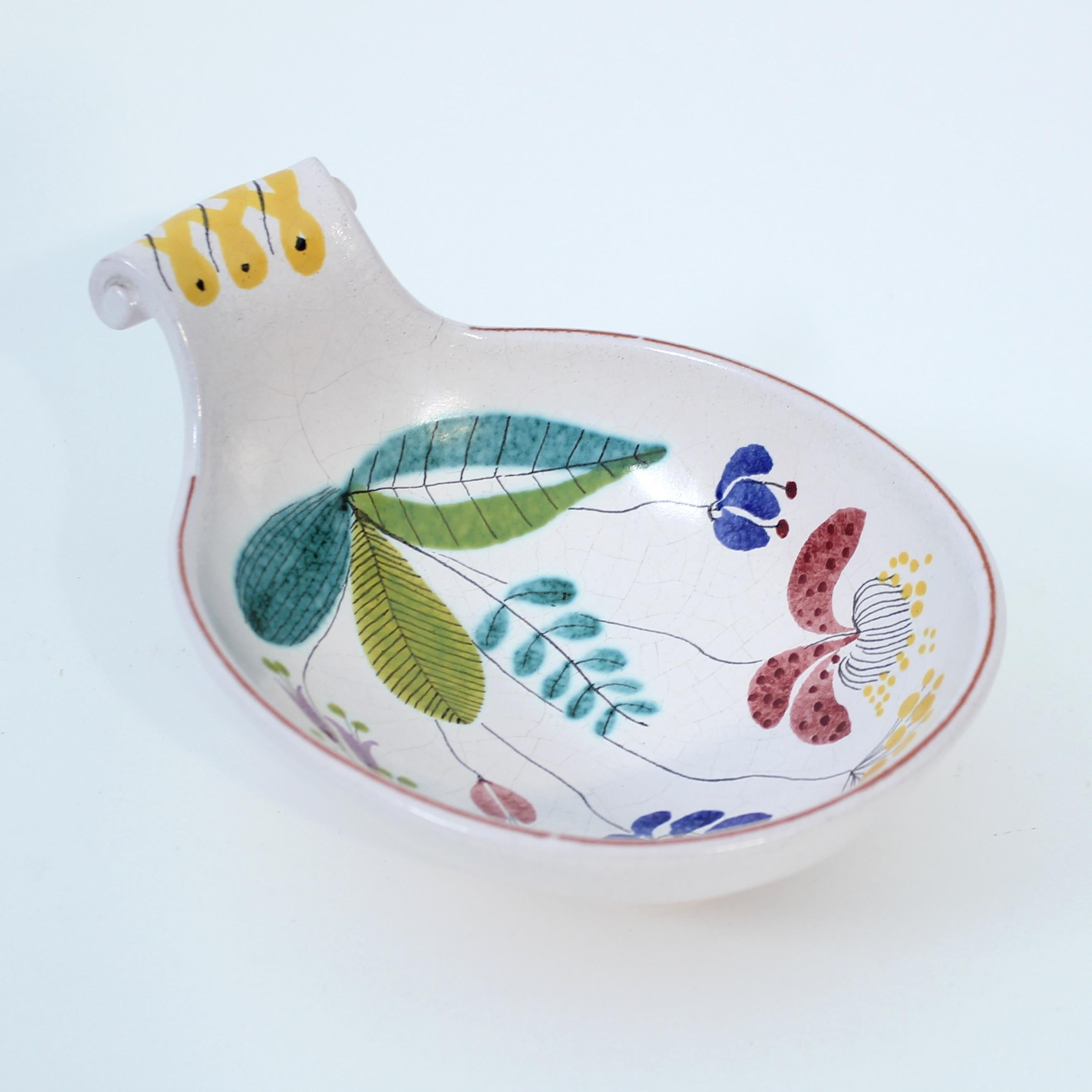 Bol / seau en faïence conçu par la légende du design suédois Stig Lindberg pour son collaborateur de longue date Gustavsberg. Modèle assez rare : une plante multicolore sur fond blanc. La poignée supérieure est ornée d'un motif jaune et noir. Bon
