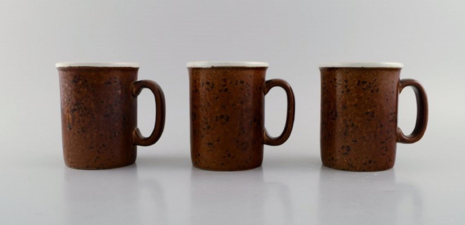 Stig Lindberg for Gustavsberg. 
Five large Coq mugs in glazed stoneware. Beautiful glaze in brown shades. 
Swedish design, 1960s.
Measures: 11.5 x 9.5 cm.
In excellent condition.
Stamped.