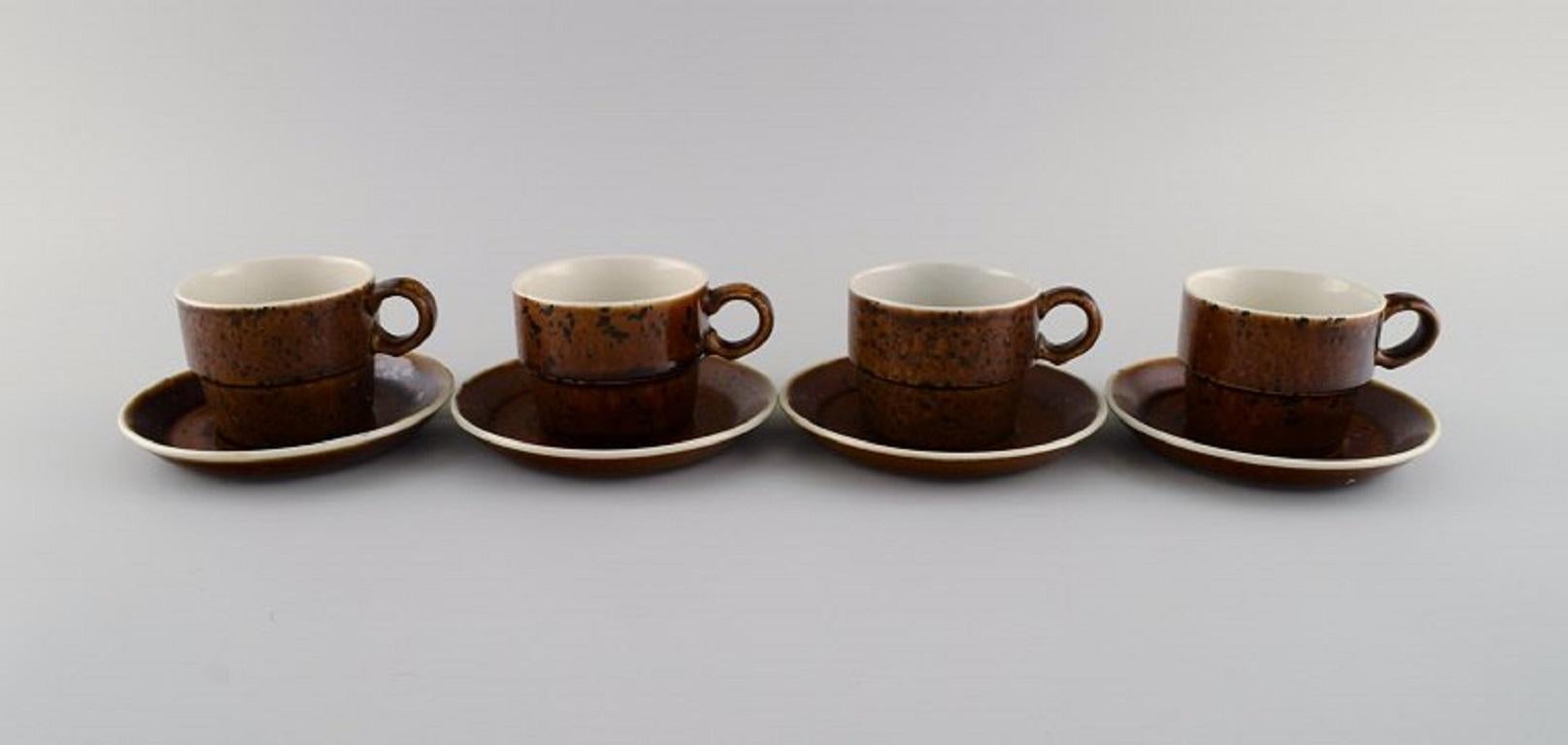 Stig Lindberg for Gustavsberg. 
Twelve Coq coffee cups with saucers in glazed stoneware. Beautiful glaze in brown shades. Swedish design, 1960s.
The cup measures: 7.5 x 6 cm.
Saucer diameter: 13 cm.
In excellent condition.
Stamped.