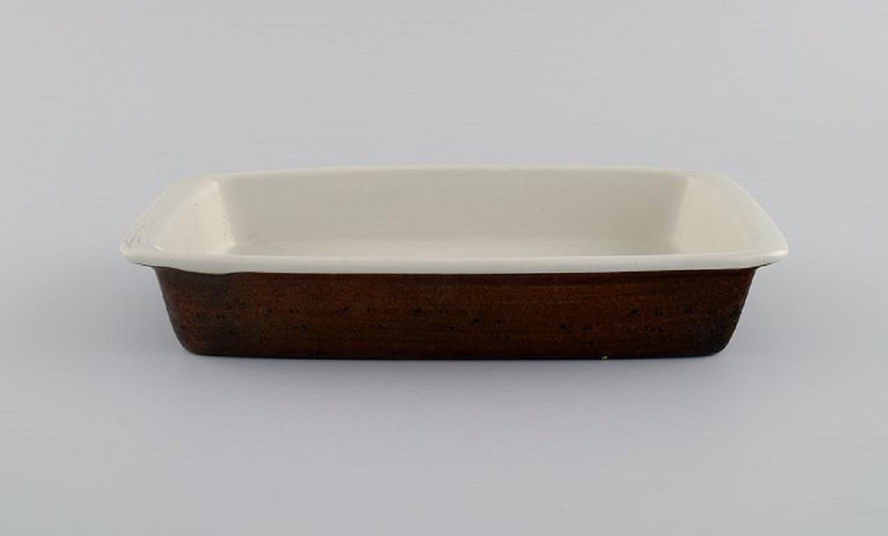 Stig Lindberg for Gustavsberg. Two Coq serving dishes in glazed stoneware. 
Beautiful glaze in brown shades. Swedish design, 1960s.
Largest measures: 43 x 25 x 4.4 cm.
In excellent condition.
Stamped.