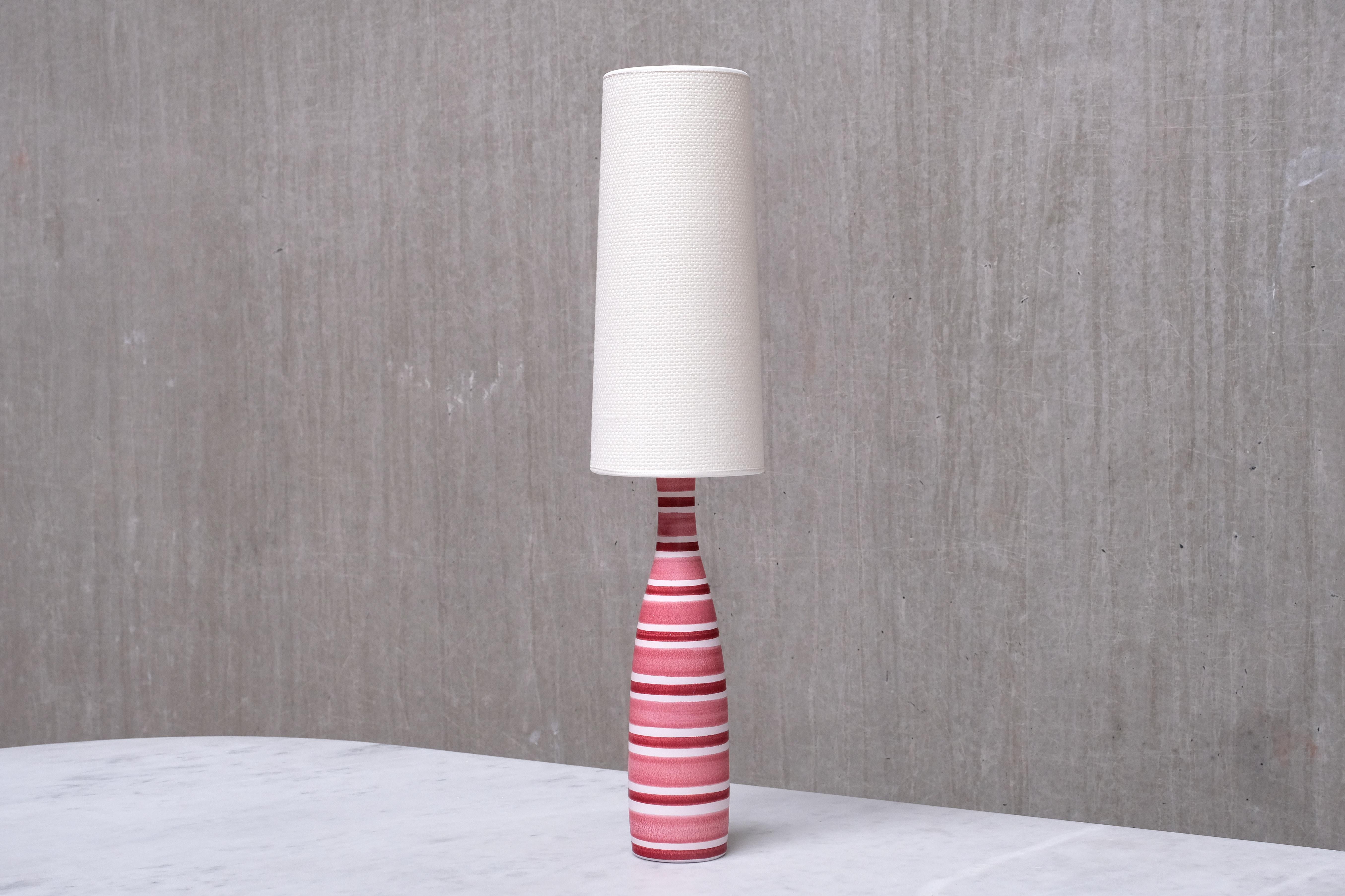 Questa lampada da tavolo elegante e sorprendente è stata disegnata da Stig Lindberg e prodotta dallo Studio A di Gustavsberg in Svezia negli anni Cinquanta. La lampada è contrassegnata sul fondo della base con l'adesivo del produttore, che include