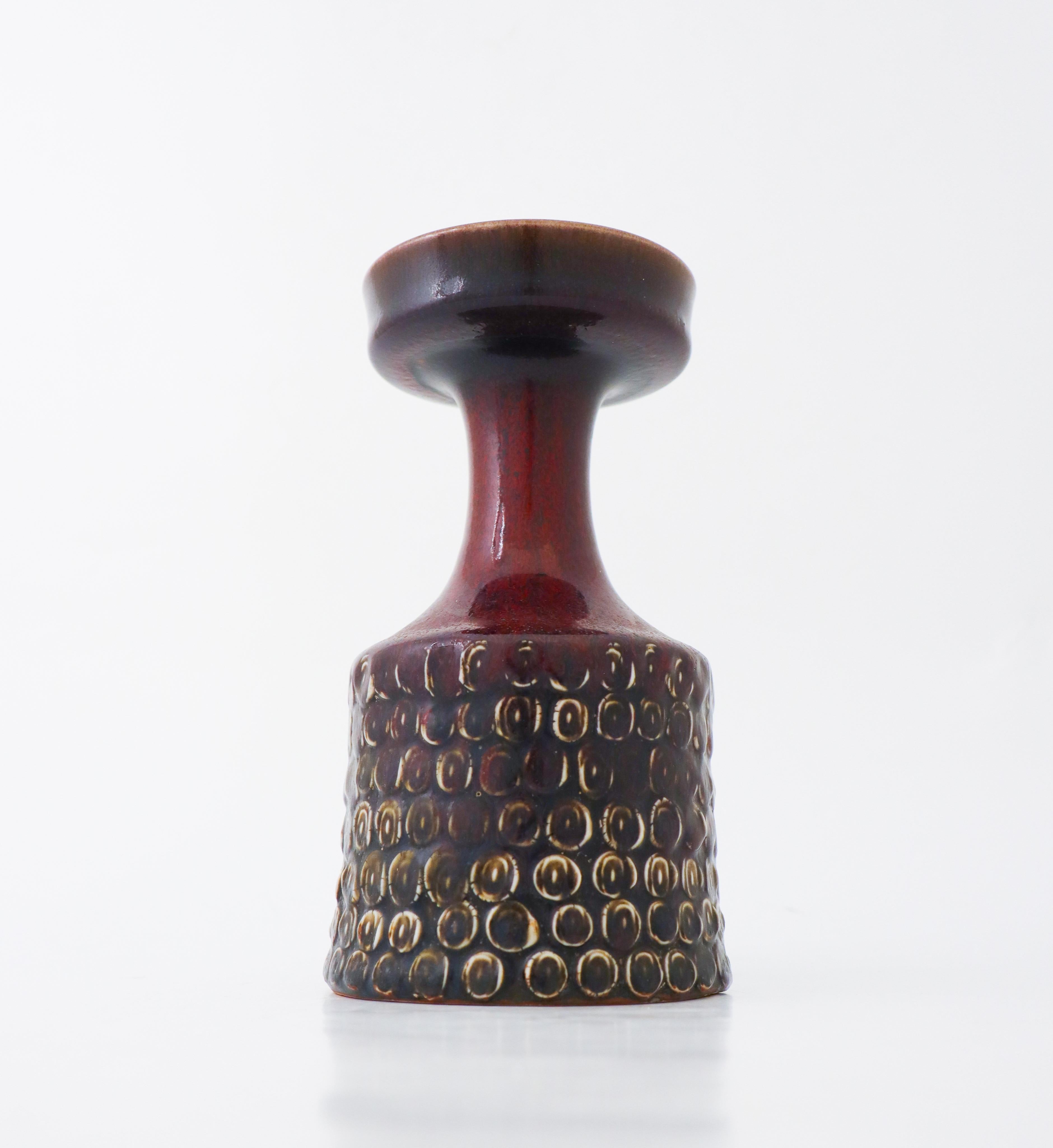 A vase designed by Stig Lindberg at Gustavsbergs Studio in Stockholm. It has an oxblood red shiny color and is in excellent condition and marked with the classical Studio hand and Stig below

Stig Lindberg is one of the most well known designers in