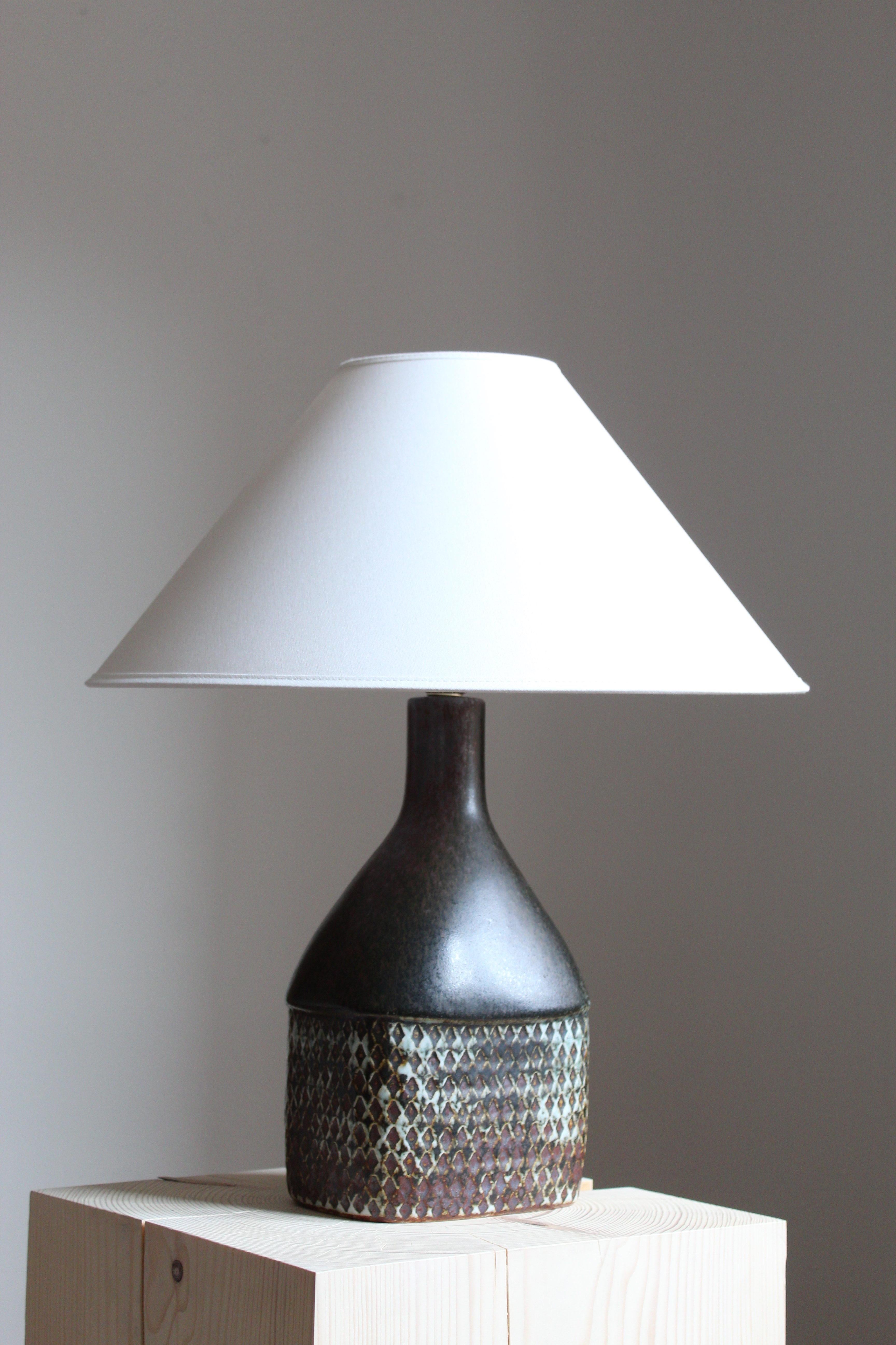 A table lamp or desk lamp designed and produced by Stig Lindberg. Produced by Gustavsberg. Marked with the Studio mark, separating this work from the large scale production series by the maker.

Sold without lampshade. Stated dimensions excluding