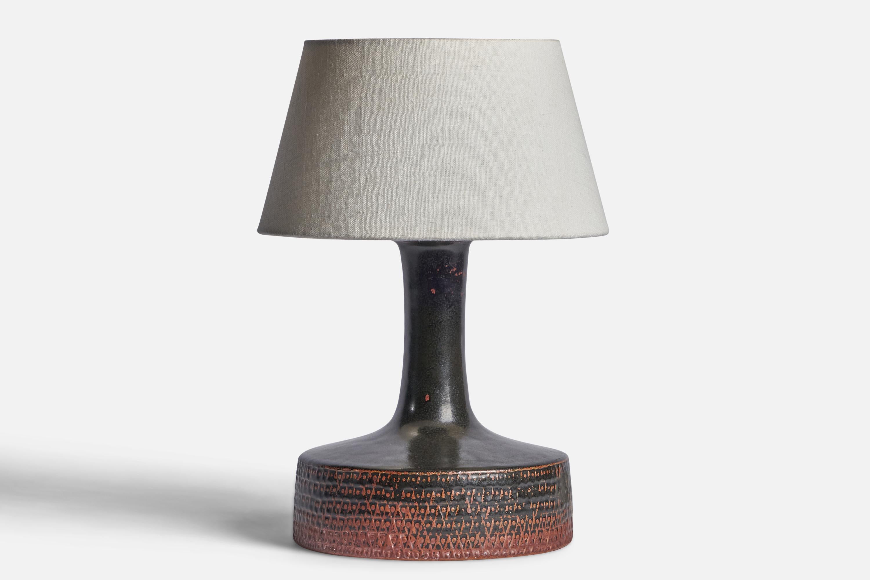 A black and orange-glazed incised stoneware table lamp designed by Stig Lindberg and produced by Gustavsberg, Sweden, 1950s.

Dimensions of Lamp (inches): 11” H x 8” Diameter
Dimensions of Shade (inches): 7” Top Diameter x 10” Bottom Diameter x
