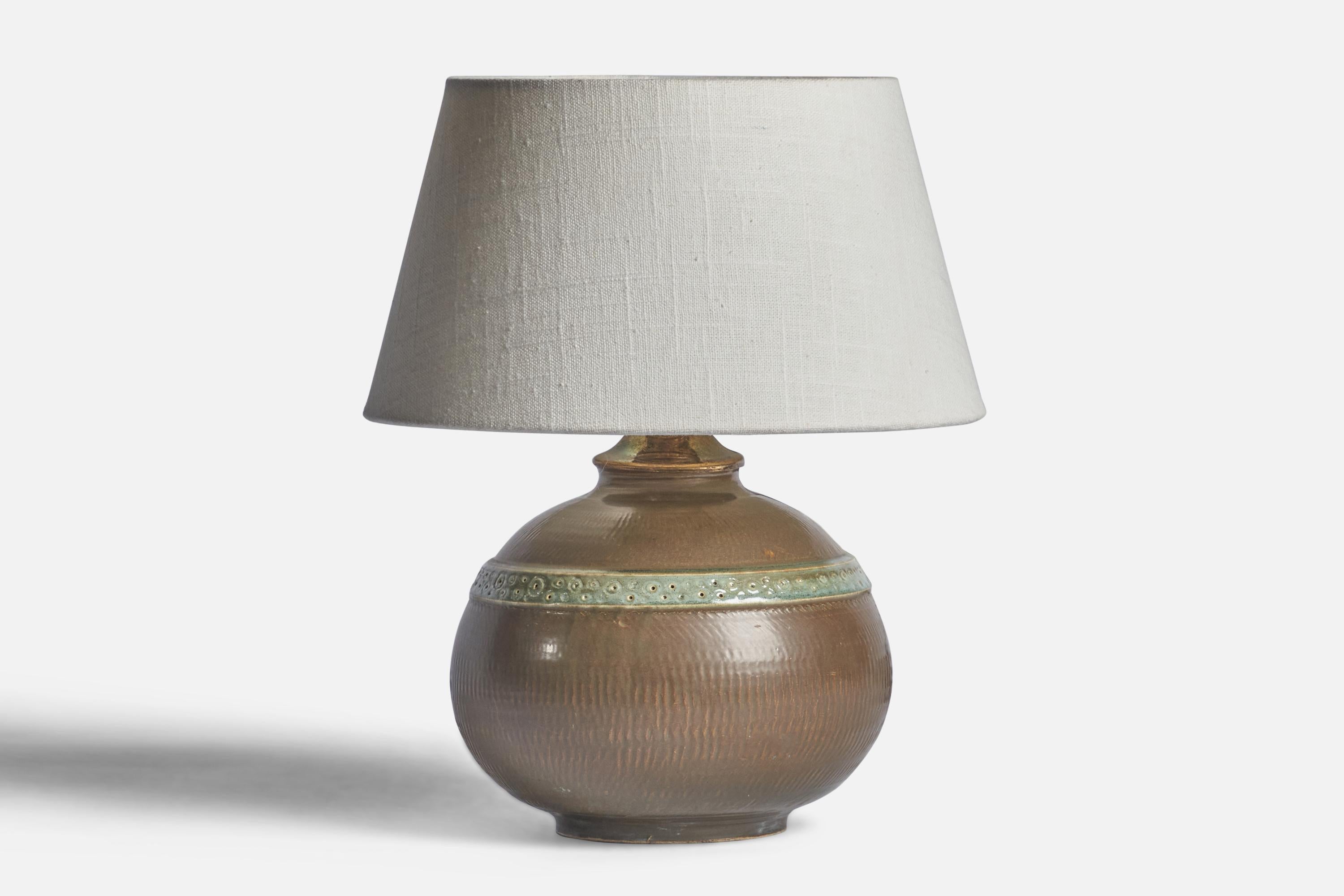 A green-glazed stoneware table lamp designed by Stig Lindberg and produced by Gustavsberg, Sweden, c. 1960s.

Dimensions of Lamp (inches): 8.75” H x 7” Diameter
Dimensions of Shade (inches): 7” Top Diameter x 10” Bottom Diameter x 5.5” H 
Dimensions