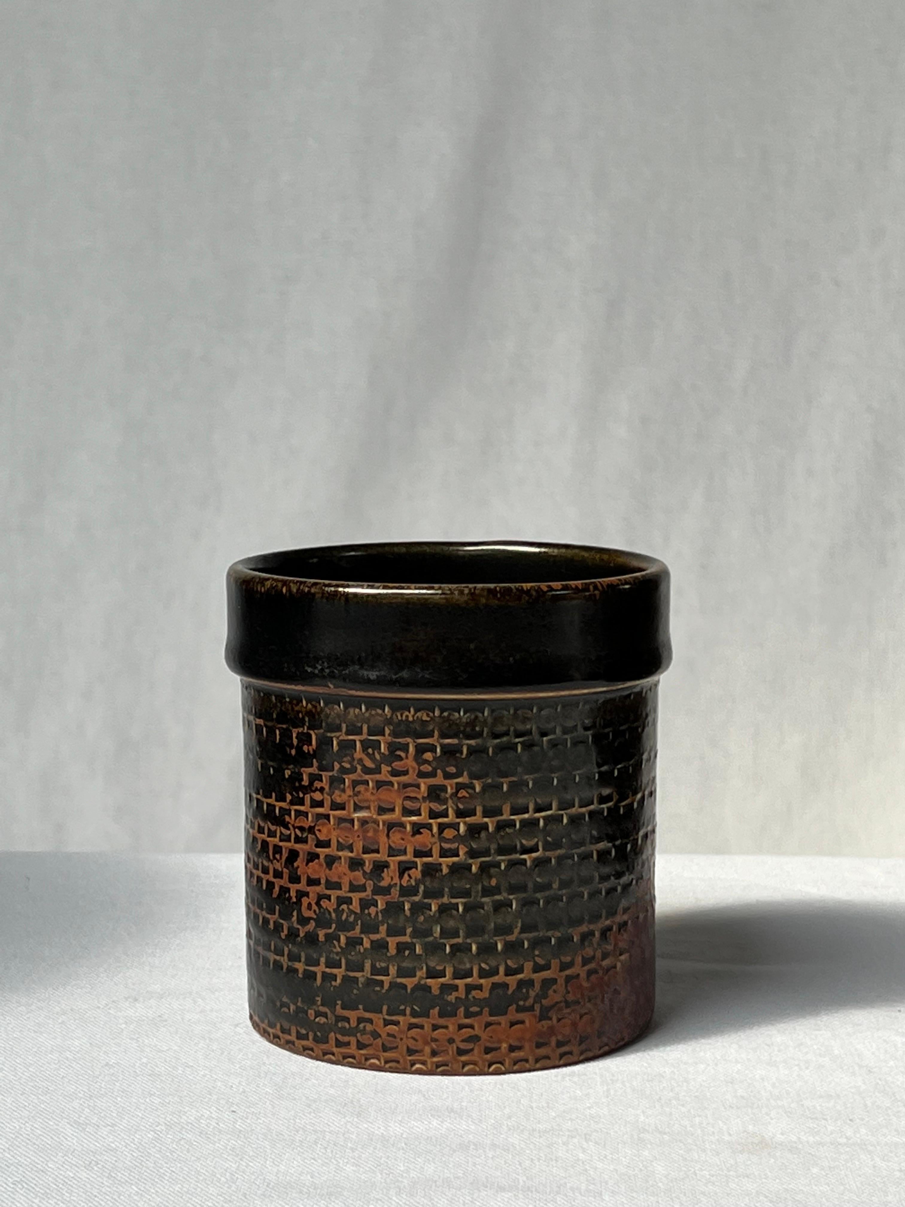 Vase émaillé noir du maître céramiste suédois Stig Lindberg. Du brun clair sur les bords au noir foncé. Il s'agit de la glaçure japonaise tenmoku, également utilisée par les anciens Chinois. Détails élégants et joli motif. Pièce unique réalisée à la