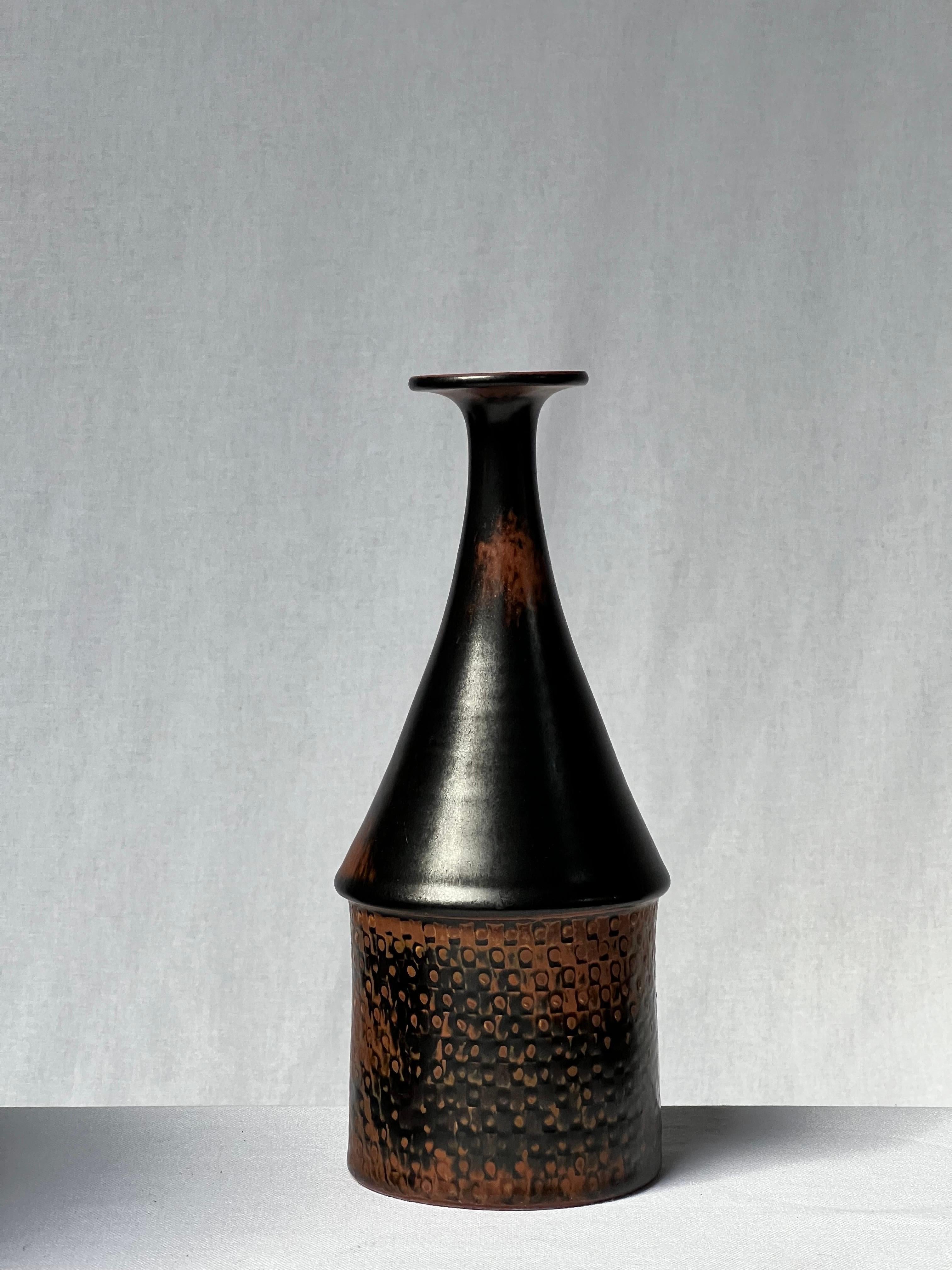 Vase émaillé noir du maître céramiste suédois Stig Lindberg. Du brun clair sur les bords au noir foncé. Il s'agit de la glaçure japonaise tenmoku, également utilisée par les anciens Chinois. Détails élégants et joli motif. Pièce unique réalisée à la