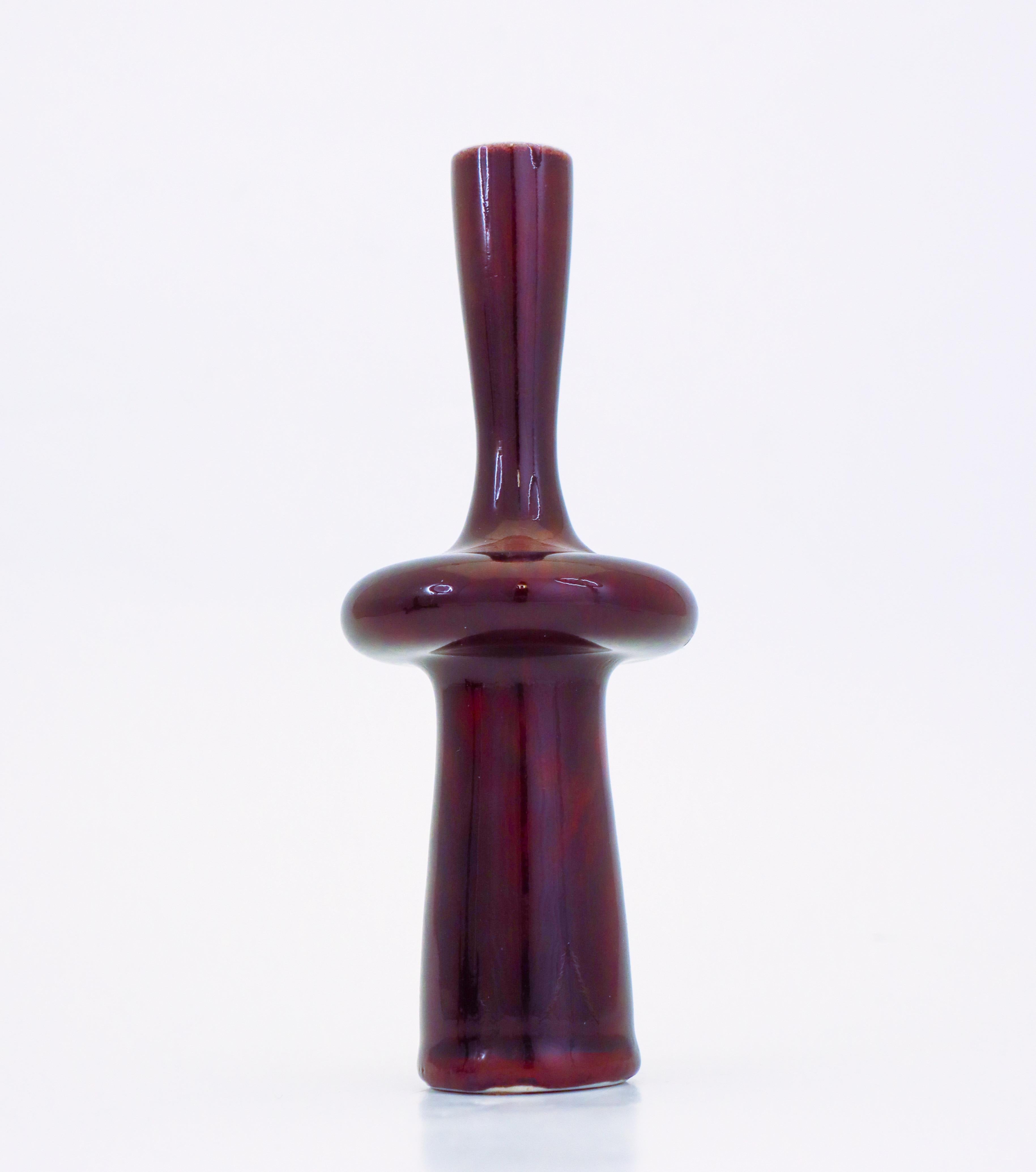 A oxblood colored porcelain vase with a lovely glossy glaze designed by Stig Lindberg at Gustavsberg. The vase is 18,5 cm high and 7.5 cm in diameter. It is in excellent condition except from some minor marks from the production. This is a uniques