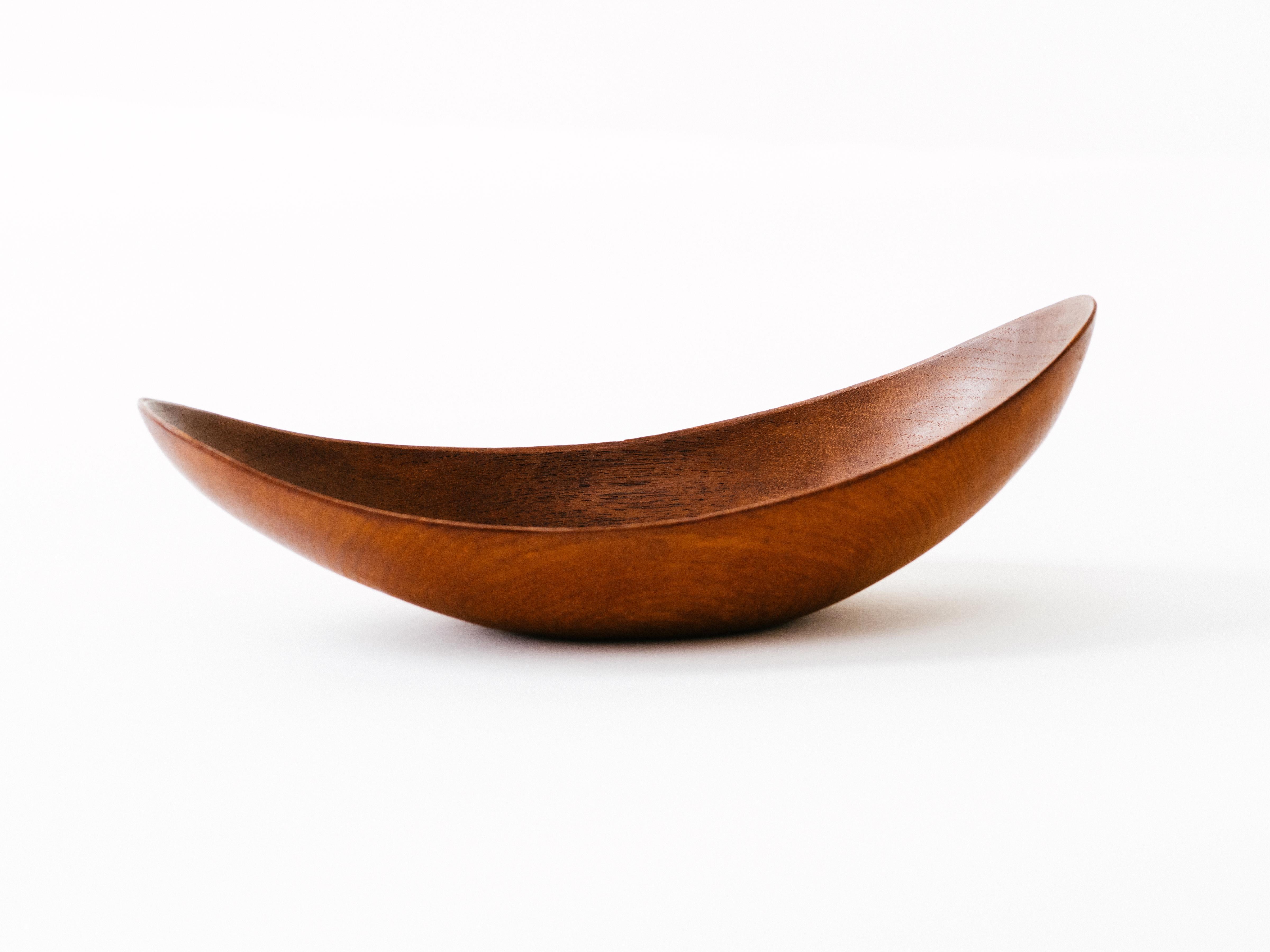 A delicate, petite bowl in teak with asymmetrically upswept ends, hand-carved by Stig Sandkvist. Signed with artist's initials to underside.