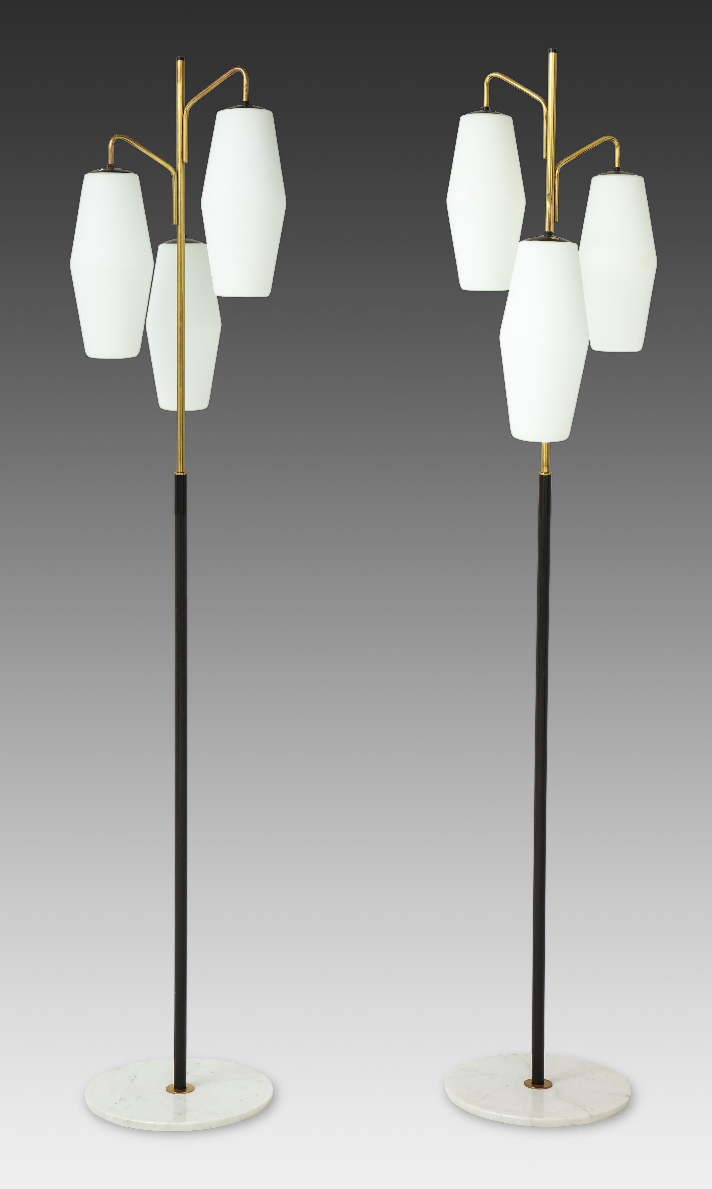 Striking and elegant Stilnovo floor lamp with three opaline glass lantern shades suspended on gilt lacquer arms and black enameled stem ending on Carrara marble base, Italy, 1960s.
Newly rewired to U.S. standards.
Only one floor lamp