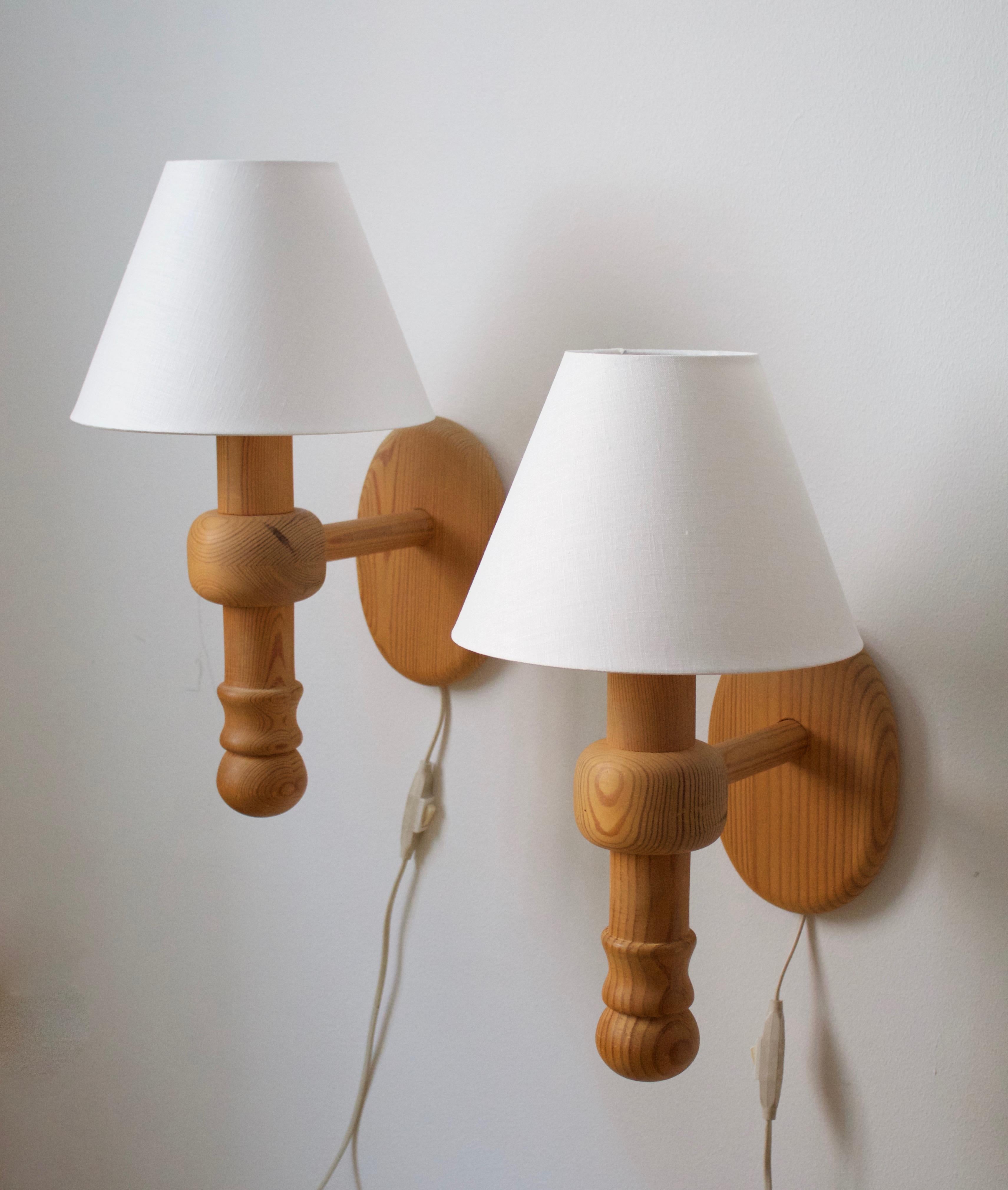 A pair of wall lights / sconces, produced by AB Stilarmatur, Tranås, Sweden. Produced in the 1970s. In solid turned pine. With brand new fabric screens.

Other designers of the period include Josef Frank, Hans-Agne Jacobsen, Paavo Tynell, Lisa
