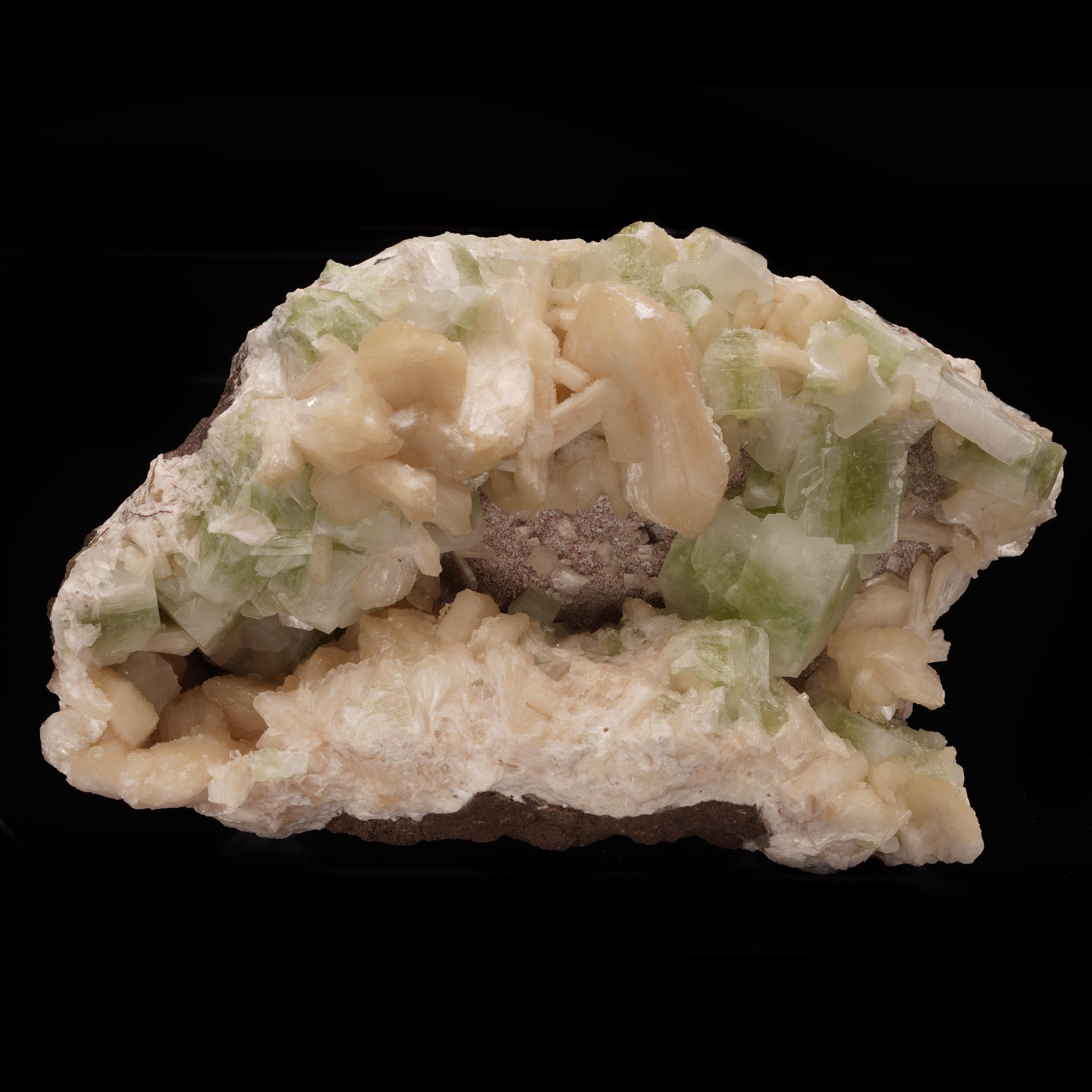 This cabinet size display piece and combination specimen features huge peach-hued stilbite crystals growing together with deeply  pigmented, equally large and fully formed green apophyllite crystals. Out of Puna, India, it will make a lustrous
