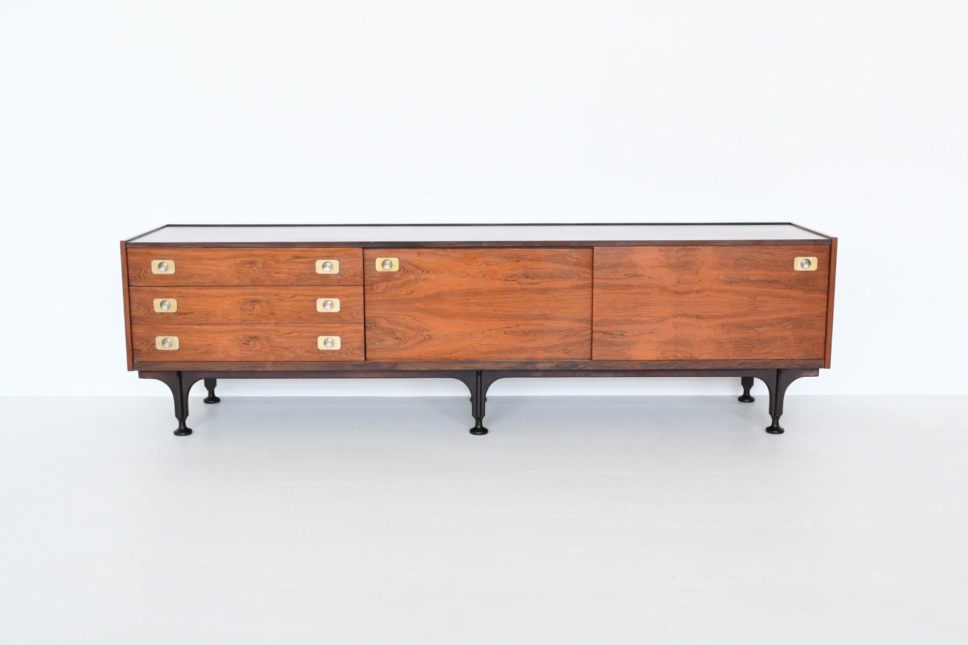 Beautiful shaped and well-crafted sideboard manufactured by Stildomus, Italy 1960. This very nice low sideboard is executed in veneered rosewood supported by a black lacquered wooden frame. It has three drawers on the left and two sliding doors on