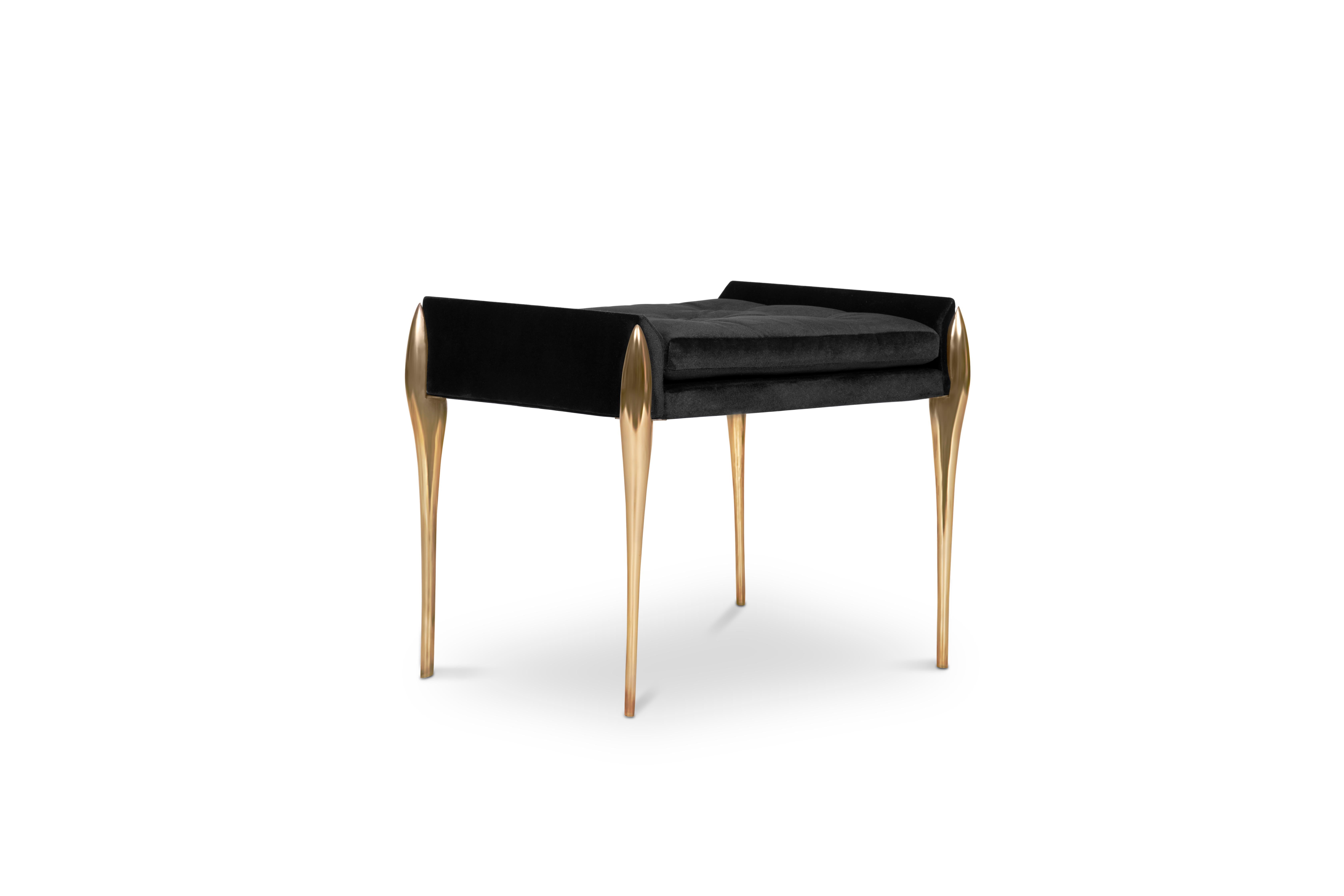 Stiletto is a button tufted bench upholstered in velvet. It features brass stiletto legs that are inspired by high heels, providing a sharp and sleek look to your bathroom. It has a rectangular cushioned pad accented by little sloping arms. Feminine