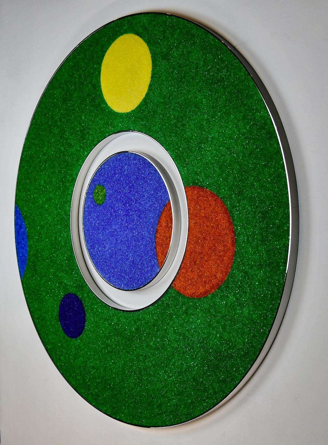 “Still In Play” is a one-of-a-kind two-piece wall sculpture. The outer circle is made with fragmented Murano glass and acrylic over a base of reclaimed wood framed by two thin bands of stainless steel polished to a mirror finish. The inner circle